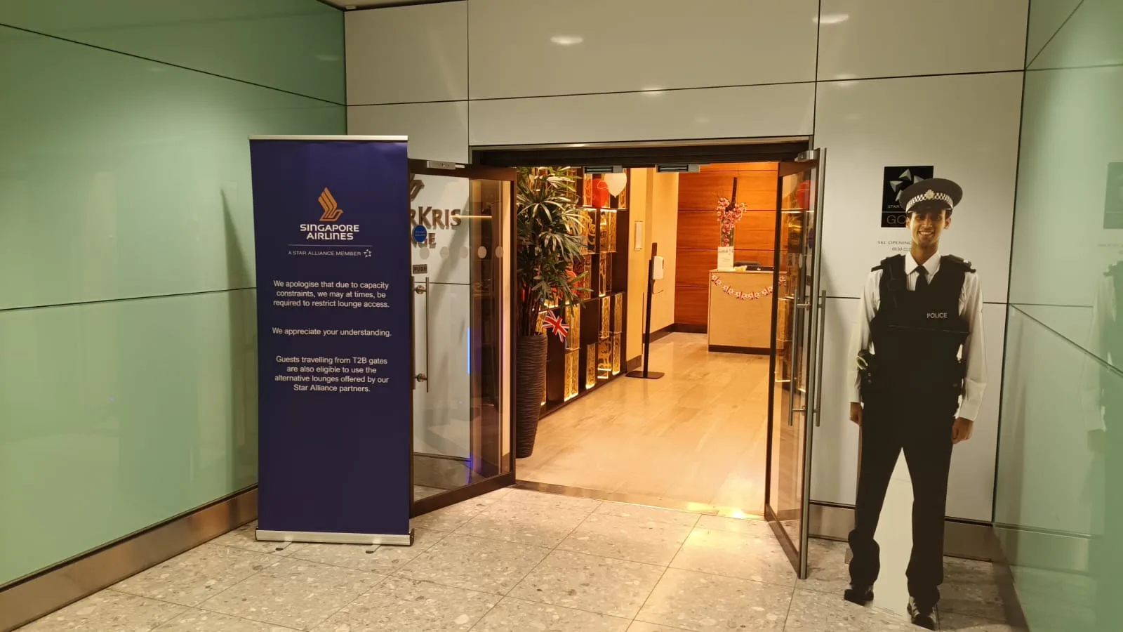 Eintritt zum Singapore Airlines Lounge mit Polizeistatue und Hinweisschild