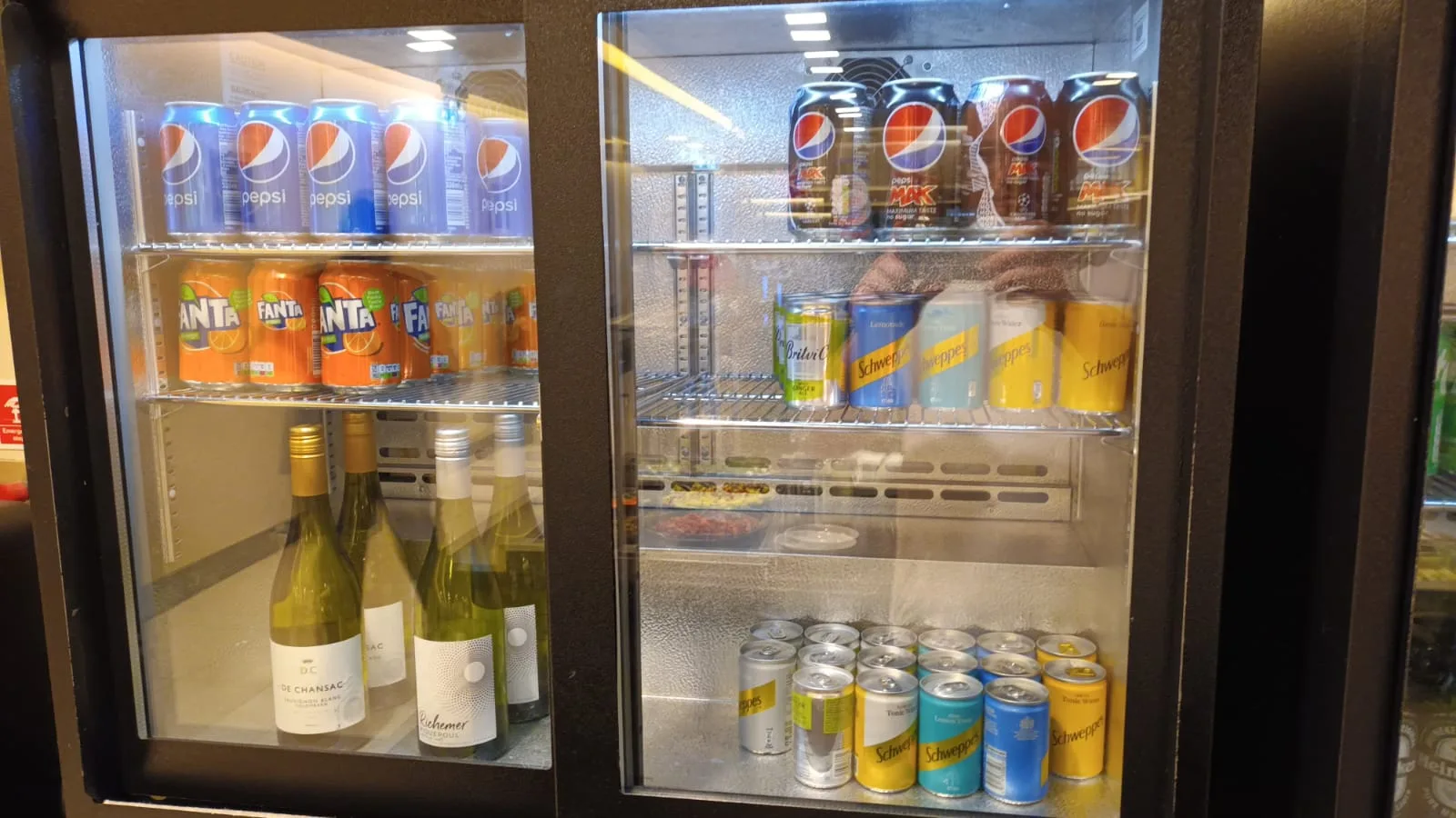 Getränkekühlschrank mit verschiedenen Getränken wie Pepsi, Schweppes und Fanta