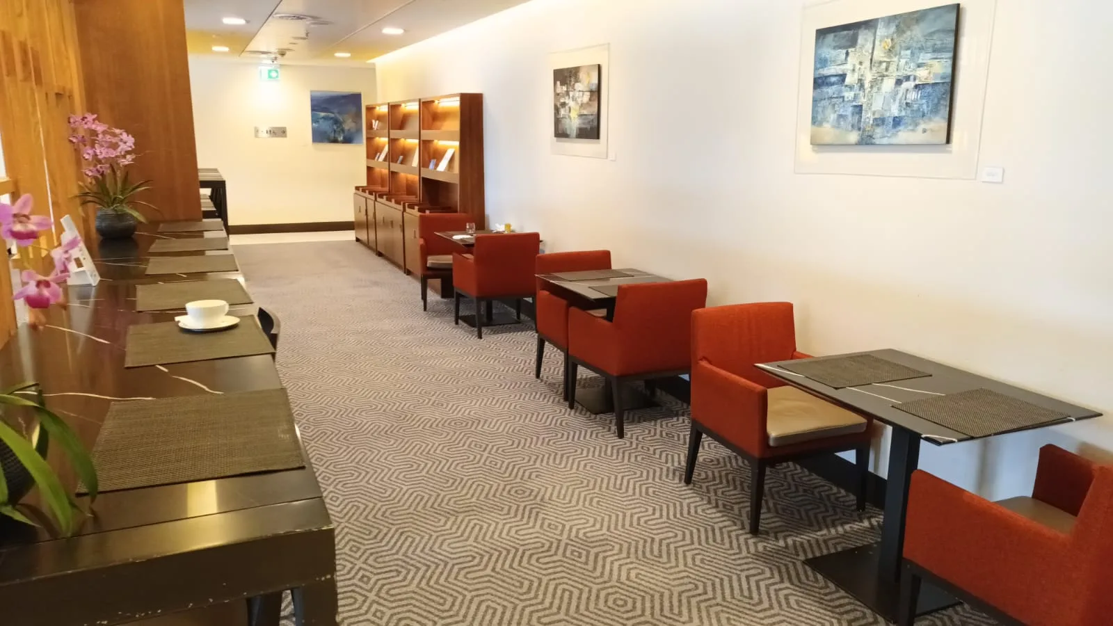 Lounge mit orangefarbenen Stühlen und gemustertem Teppich