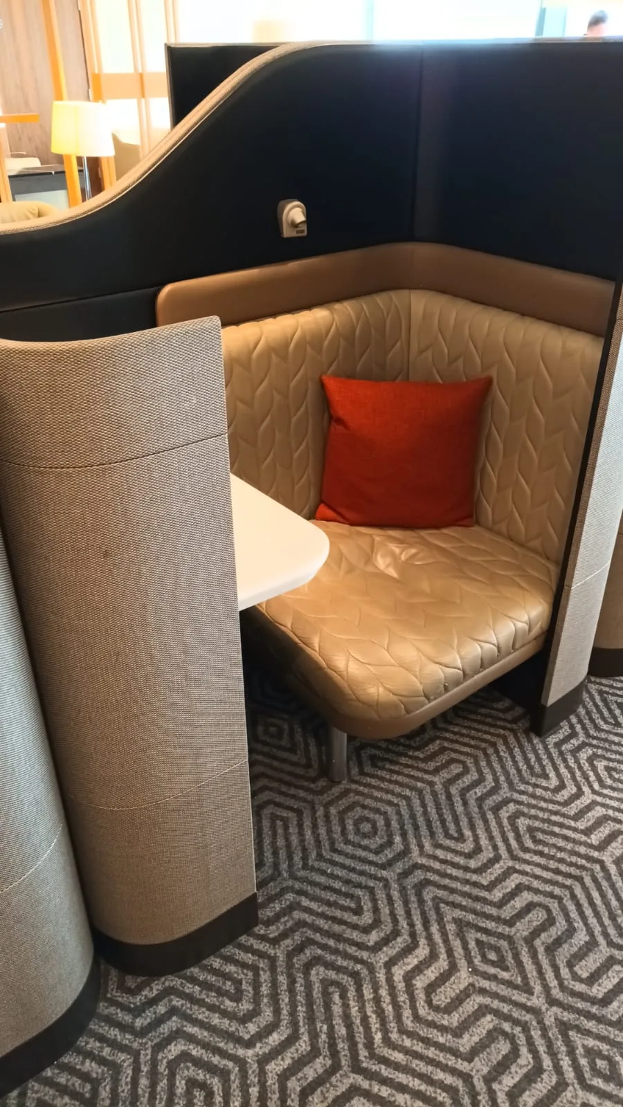 Einzelplatz im Flughafenlounge mit gepolstertem Sitz und Kissen
