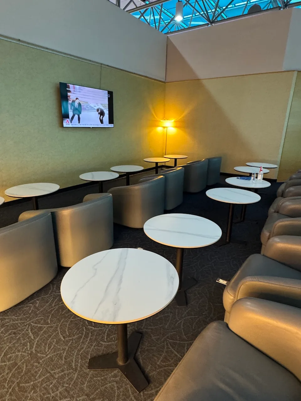 Lounge mit Sesseln und runden Tischen