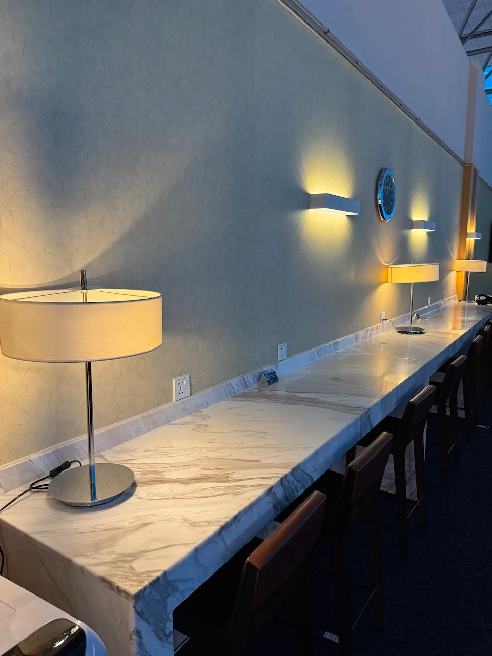 Lounge-Tisch mit Marmorplatte und Lampen an der Wand