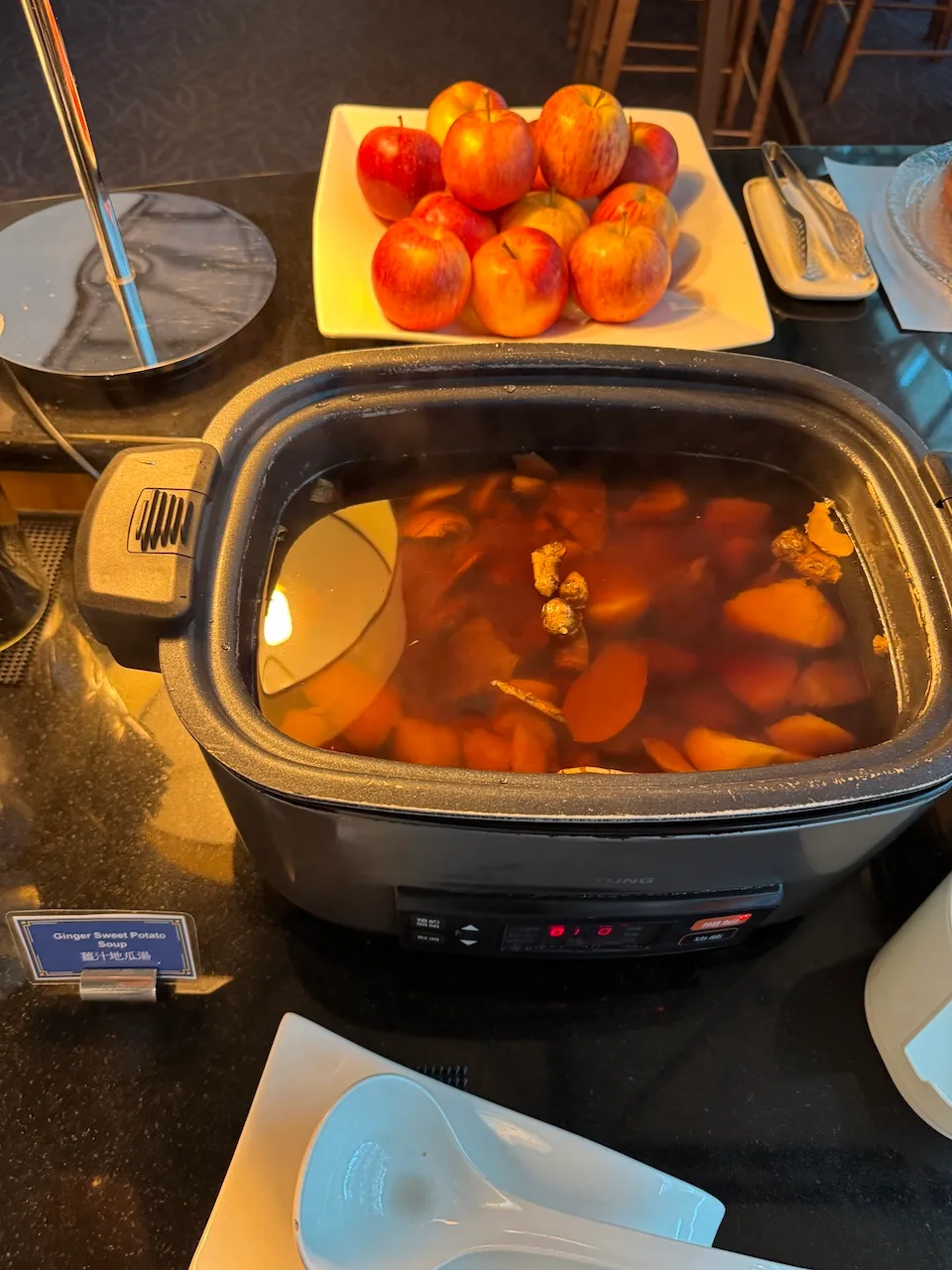 Ginger Sweet Potato Soup in Elektro-Kochtopf mit Äpfeln im Hintergrund