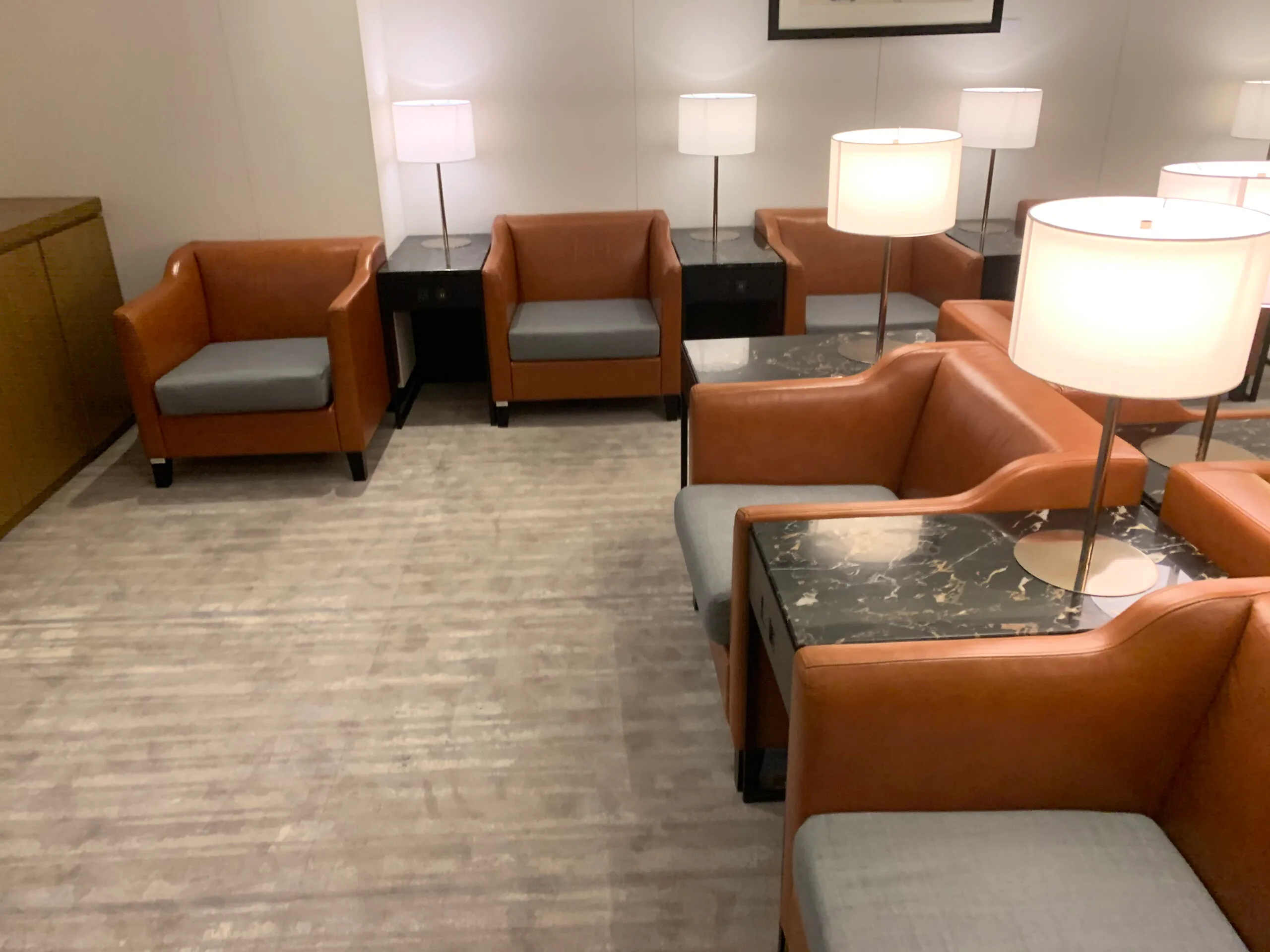 Lounge mit orangefarbenen Ledersesseln und Nachttischen