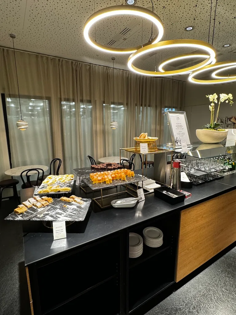 Buffet mit verschiedenen Gebäcksorten und Getränken in einem Sky Lounge