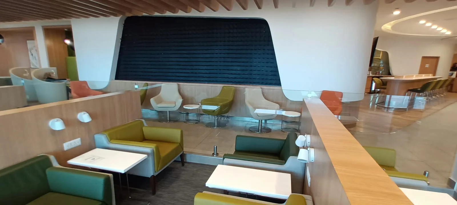 Lounge mit Sitzplätzen und Tischen in pastellfarbenen Farbtönen