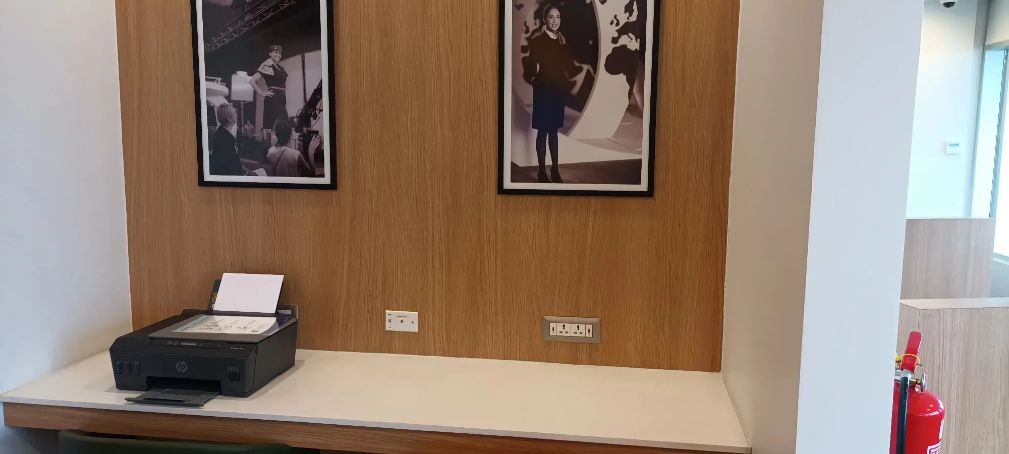 Drucker auf Schreibtisch mit Bildern an der Wand