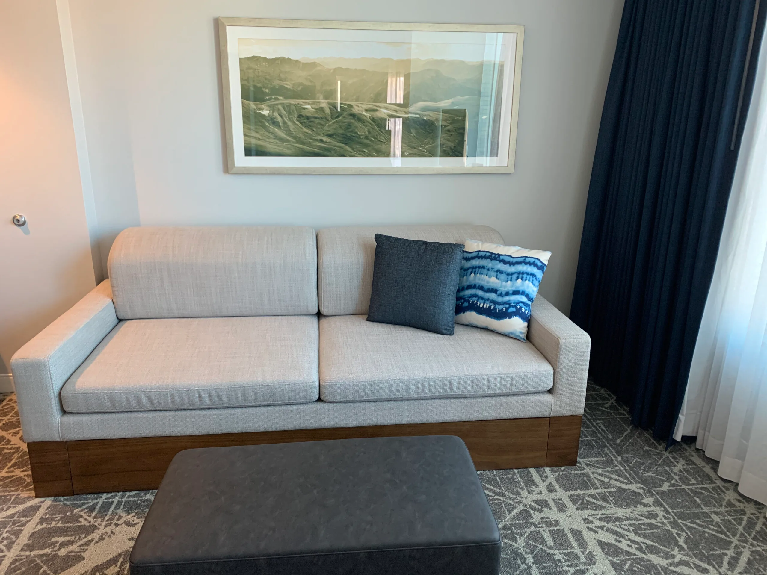 Graues Sofa mit Kissen vor Wandbild