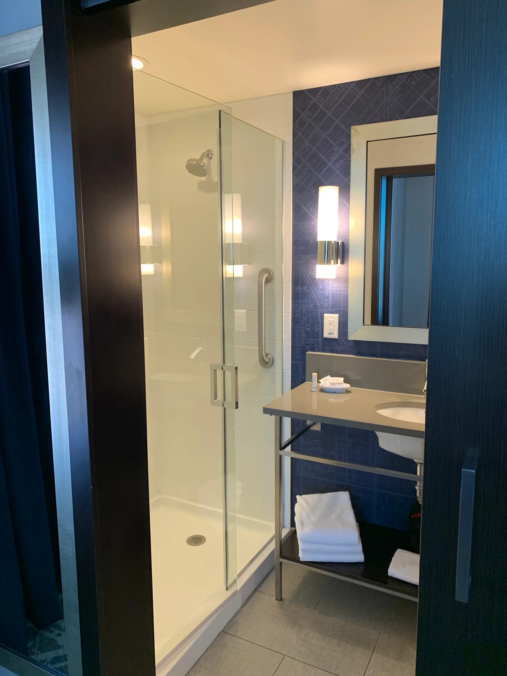 Glaswand im Hotel mit Holzregal und Teppichboden