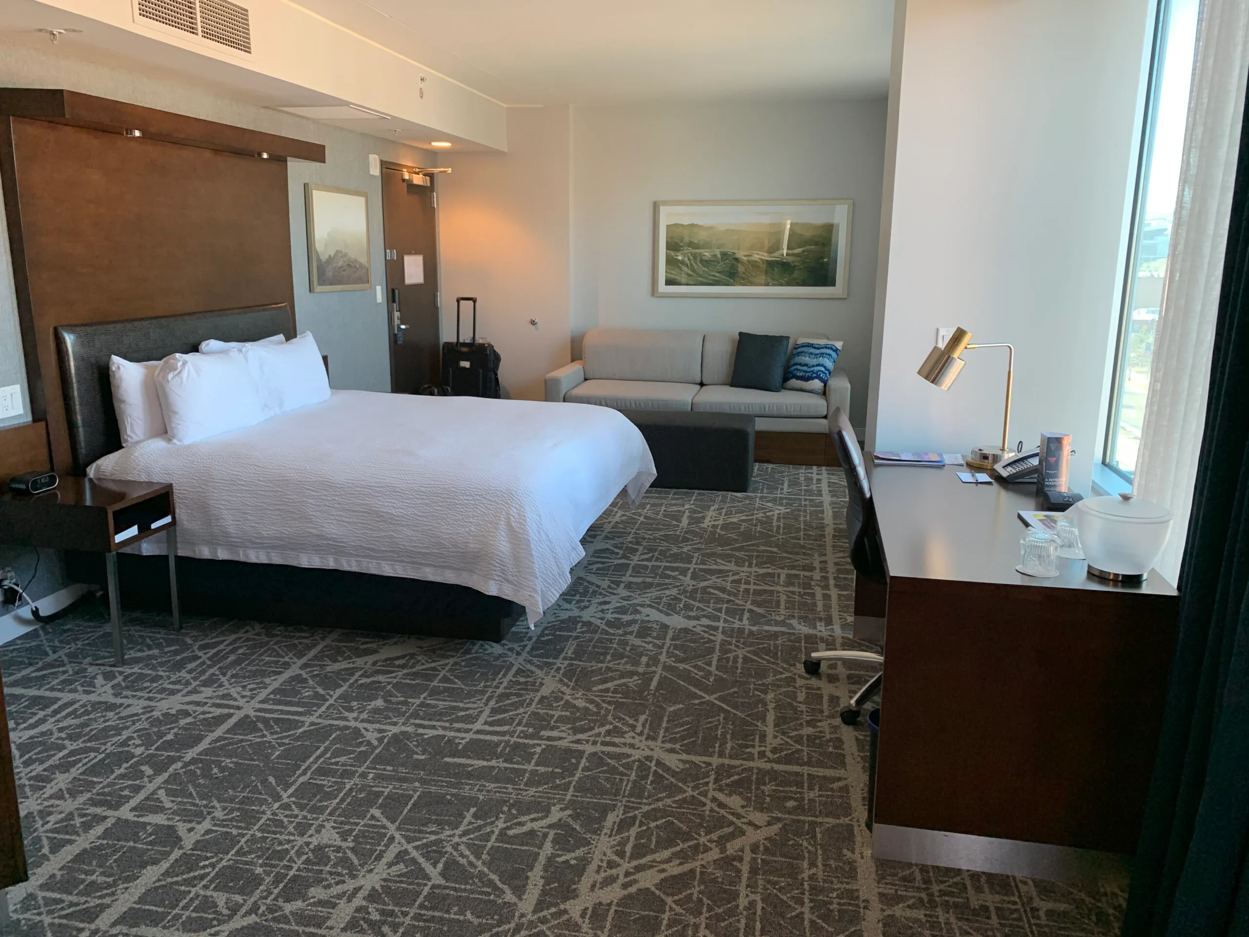 Hotelzimmer mit Doppelbett und Couch in Grautönen
