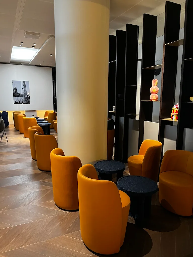 Gelbe Sessel in Lounge mit schwarzen Tischen und Säulen