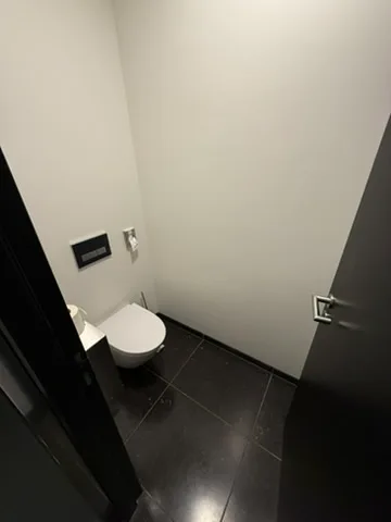 kleine Toilette mit Fliesenboden und Toilette