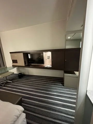 Hotelzimmer mit Schrank und Flachbildfernseher