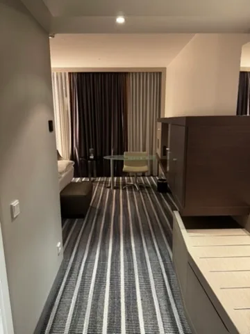 Hotelzimmer mit Doppelbett und gestreiftem Teppich