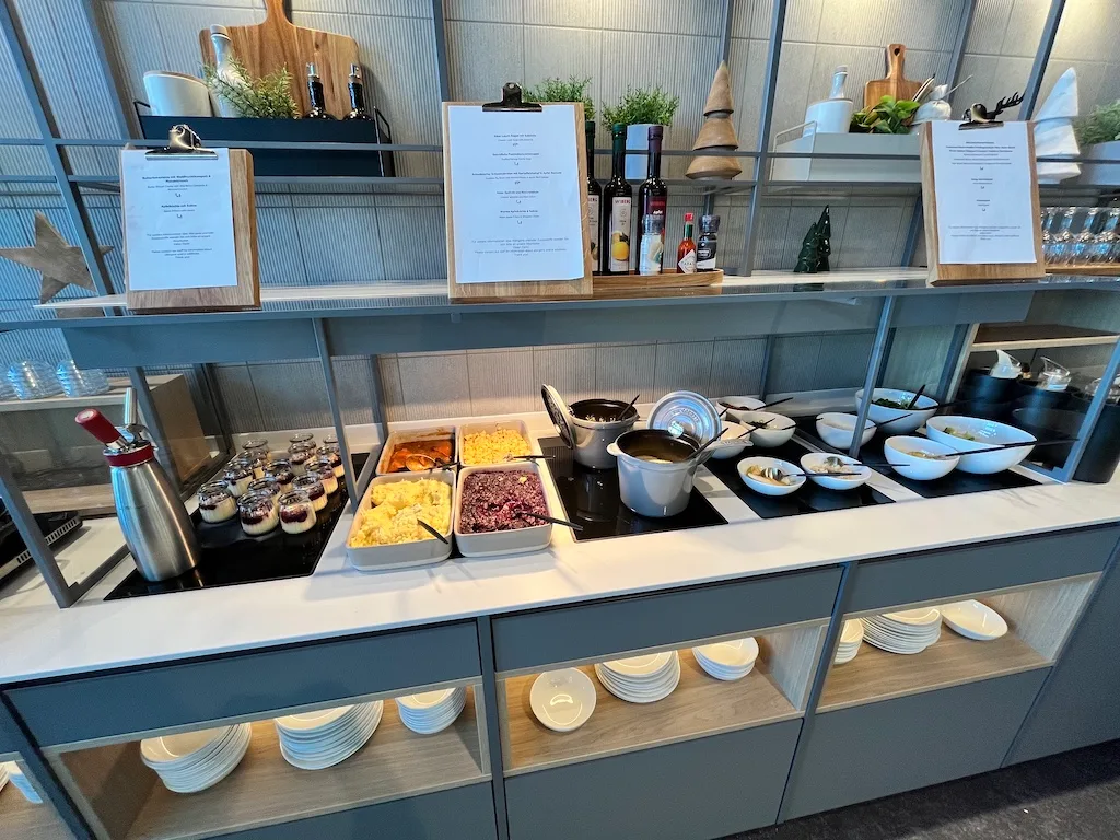 Buffet mit verschiedenen Gerichten und Menükarten im Lufthansa Senator Lounge
