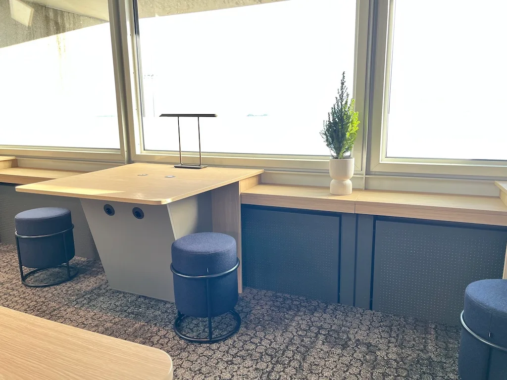 Lounge mit Tisch und Stühlen vor Fenster