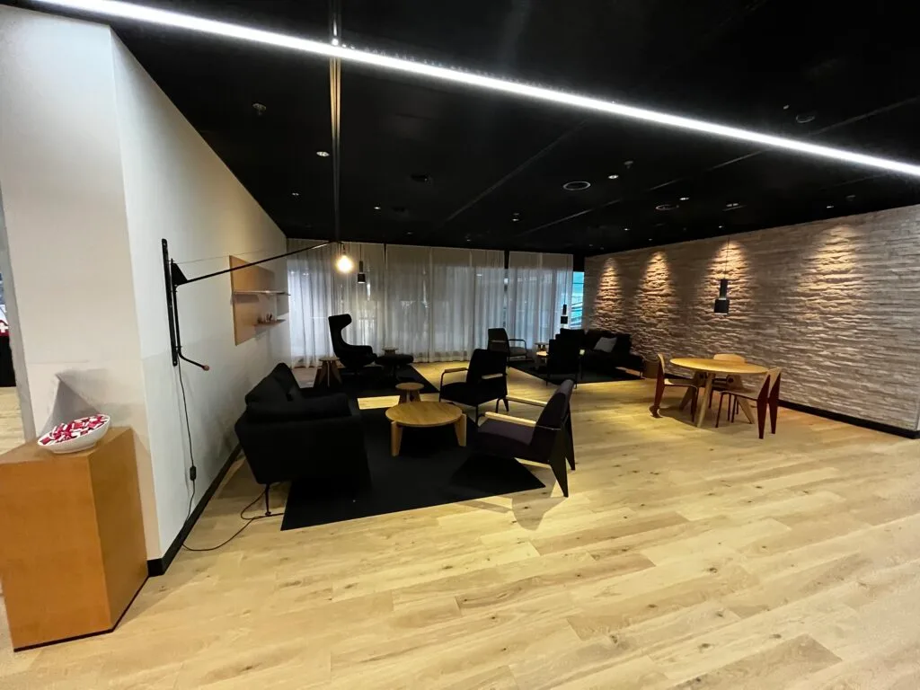 Lounge mit schwarzen Sofas und Holzboden im Flughafen