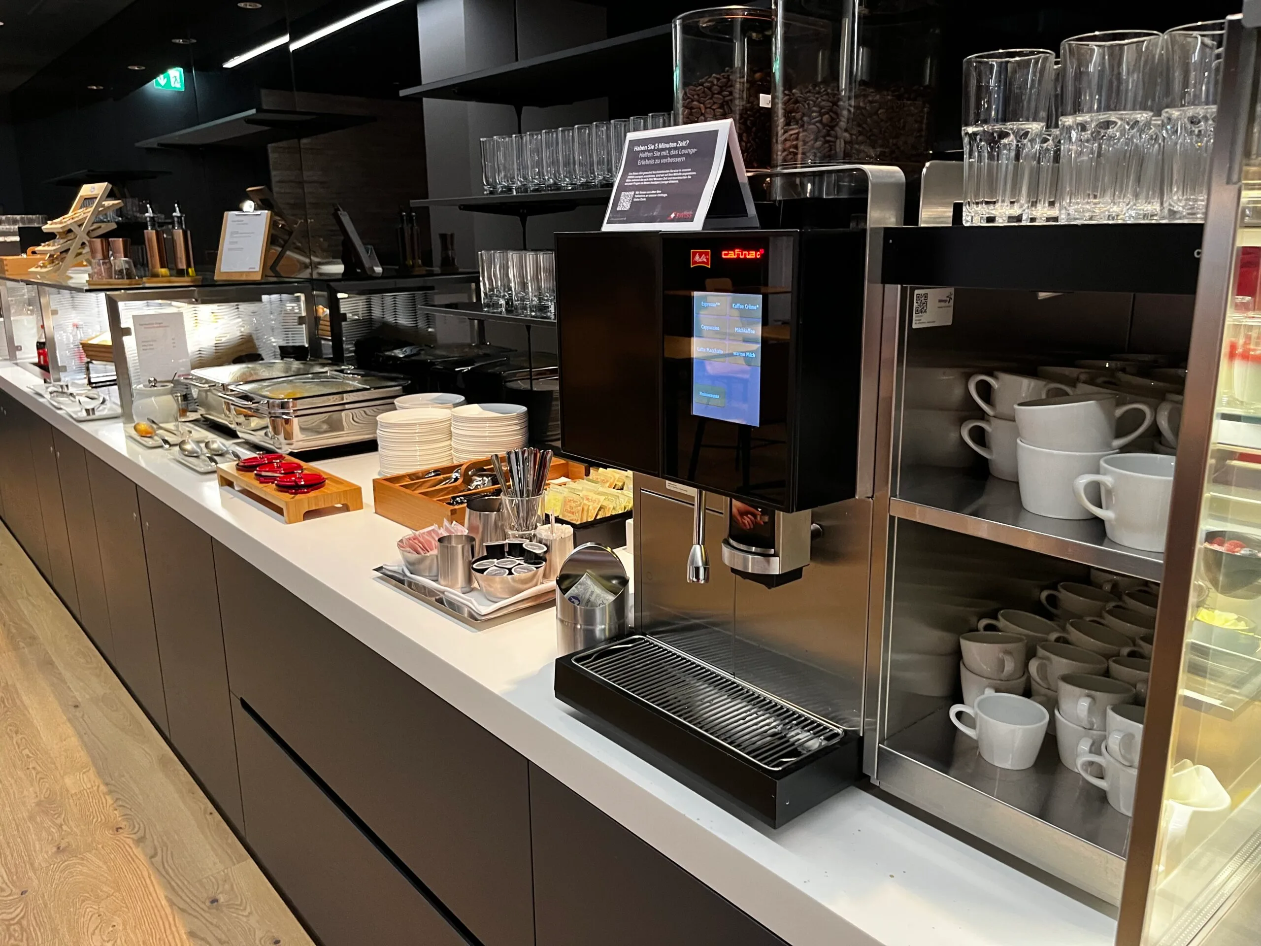 Kaffeebar im Swiss Arrival Lounge mit Kaffeemaschine und Geschirr
