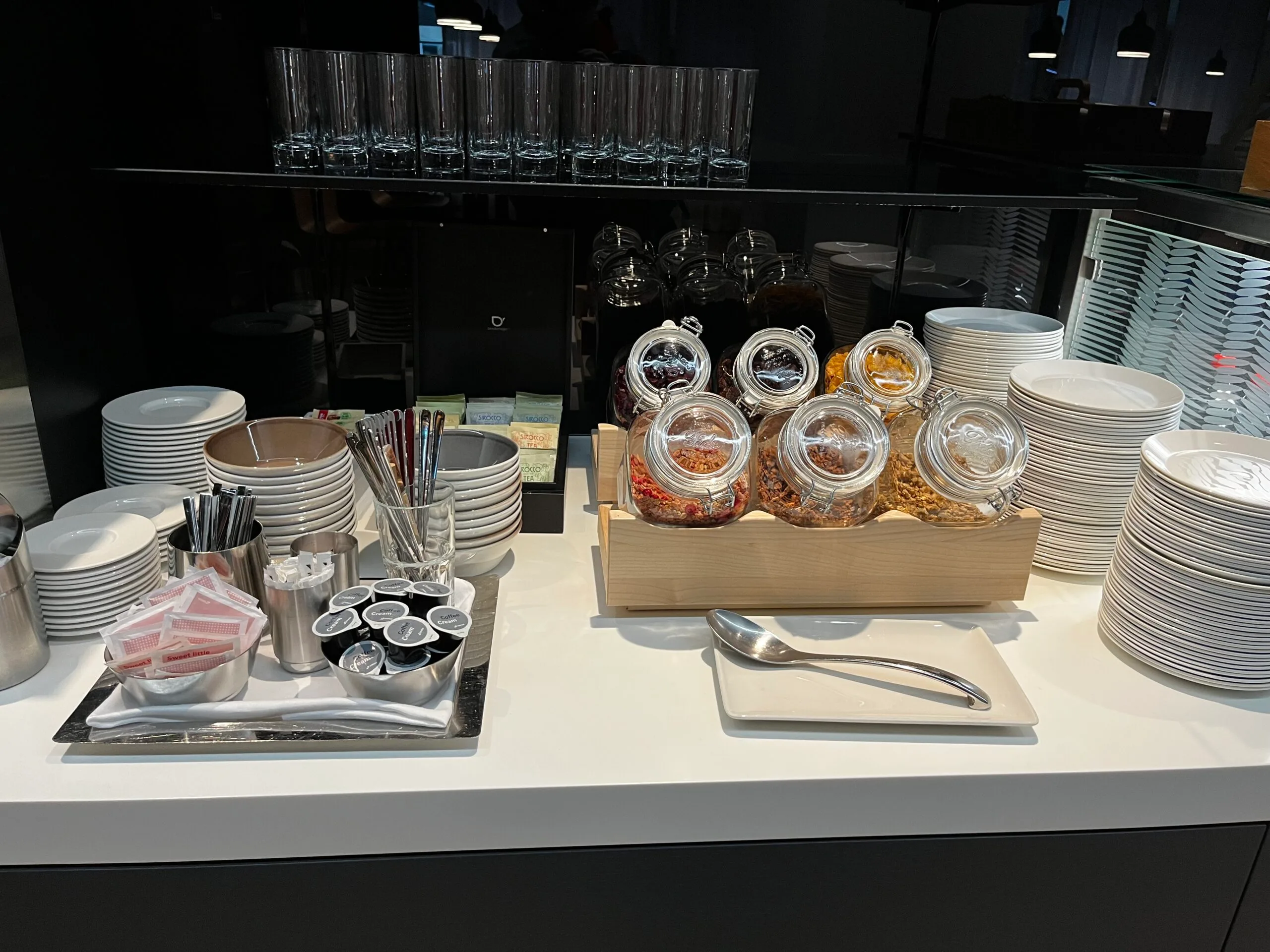 Buffet mit Tassen, Schalen und Gewürzbehältern auf weißem Tisch