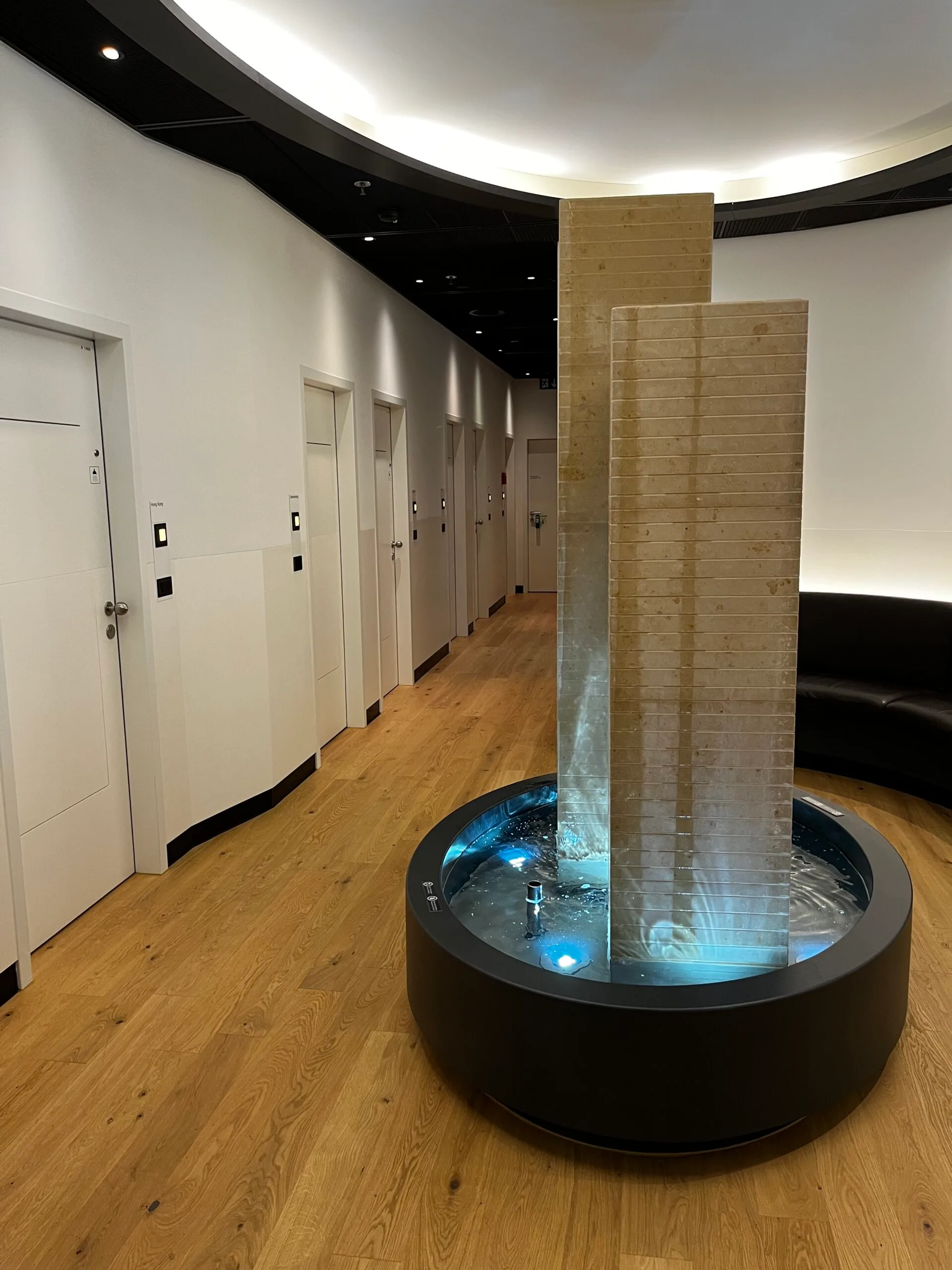 Wasserfall im Loungebereich mit Holzverkleidung und Beleuchtung