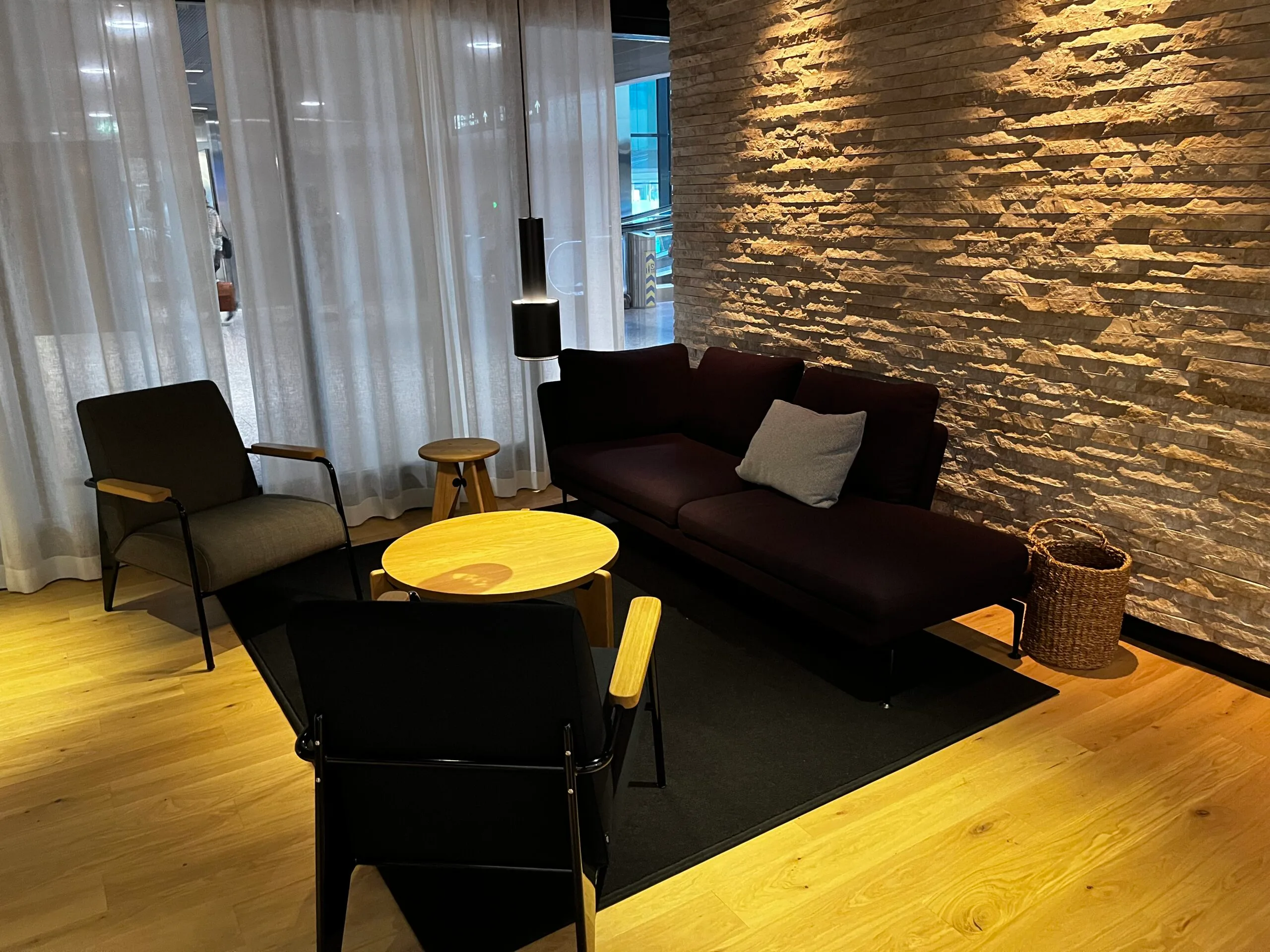 Lounge mit Sessel und Tisch vor Flughafenfenster