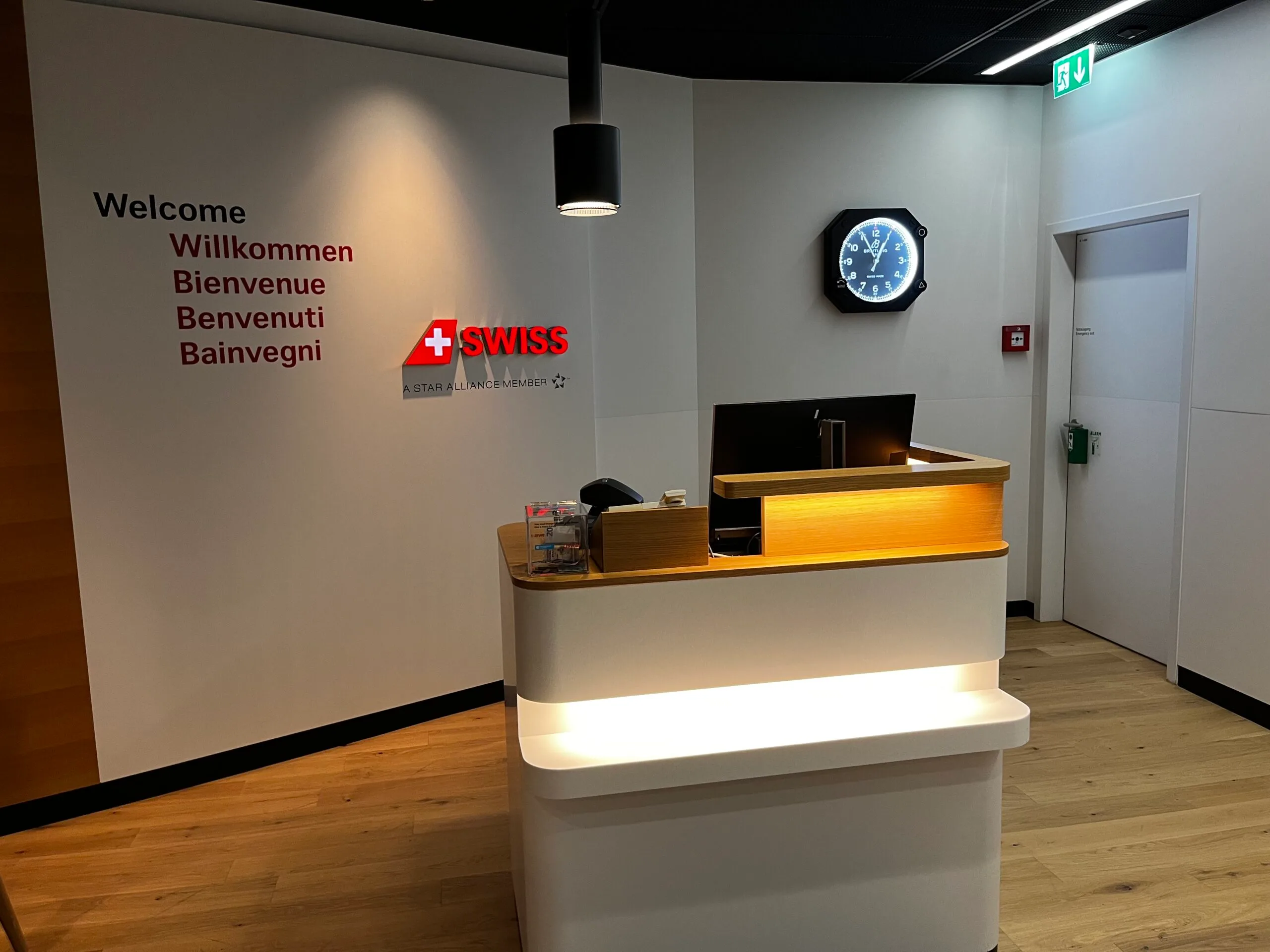 Willkommensschild mit verschiedenen Sprachen und Swiss-Logo an Empfangsdesk
