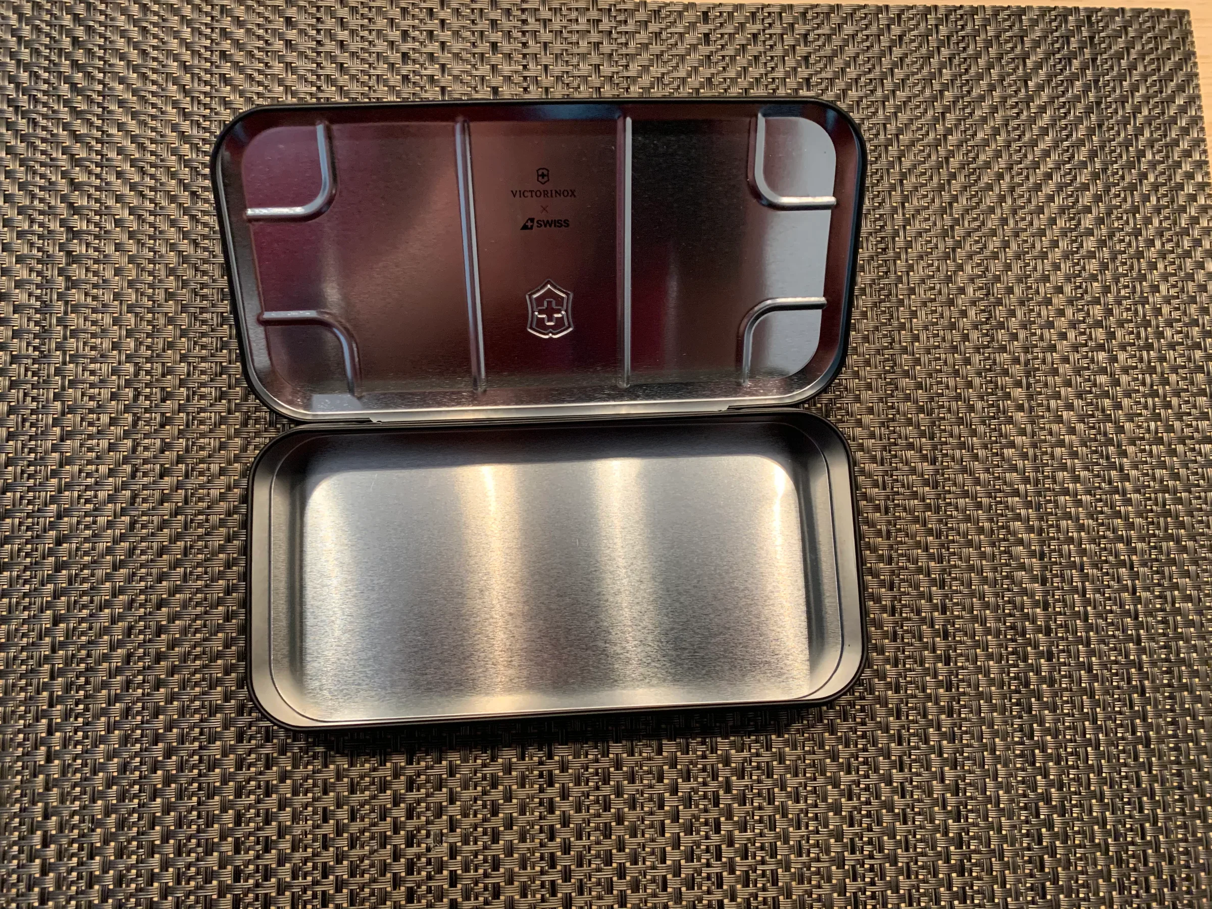 Metallische Box mit Victorinox-Logo und Aufteilung für Gegenstände