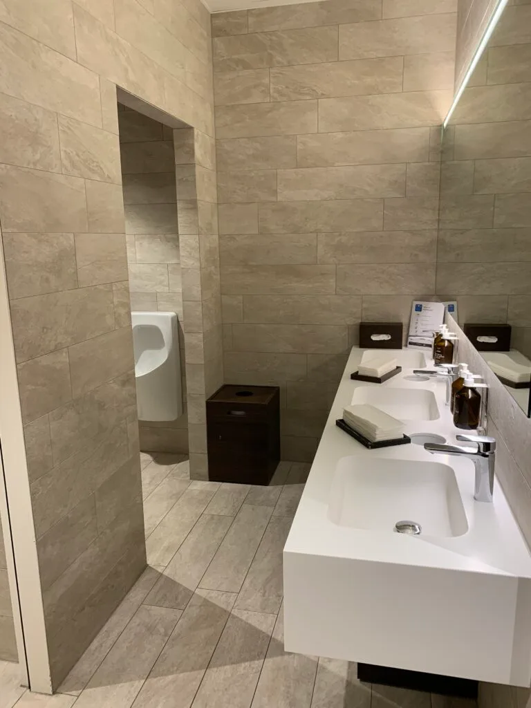 Moderne Toilette mit Urinal und Papierkorb