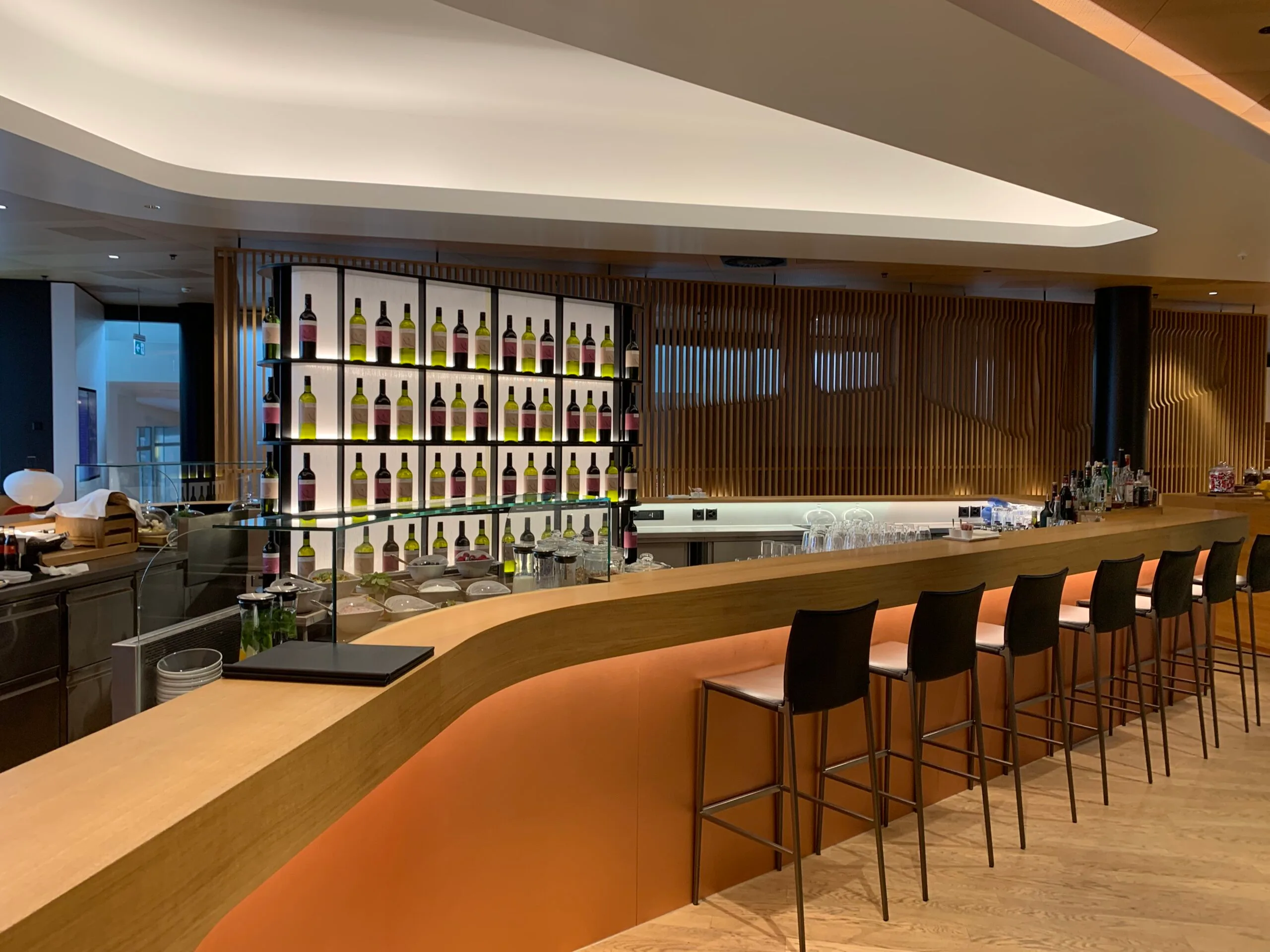 Bar mit Holzregal und Weinflaschen im First Class Lounge