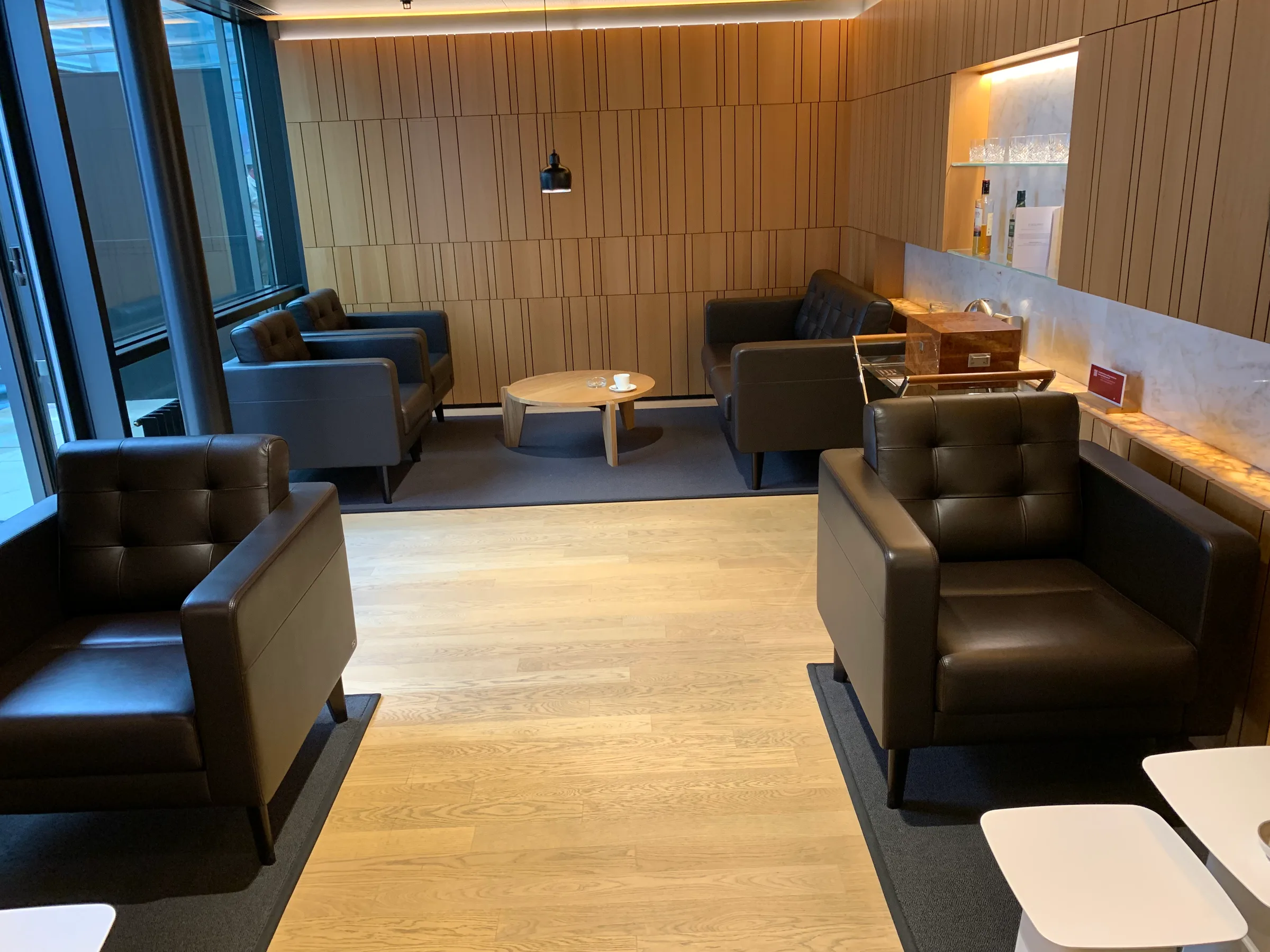 Lounge mit Ledersesseln und Holzwänden
