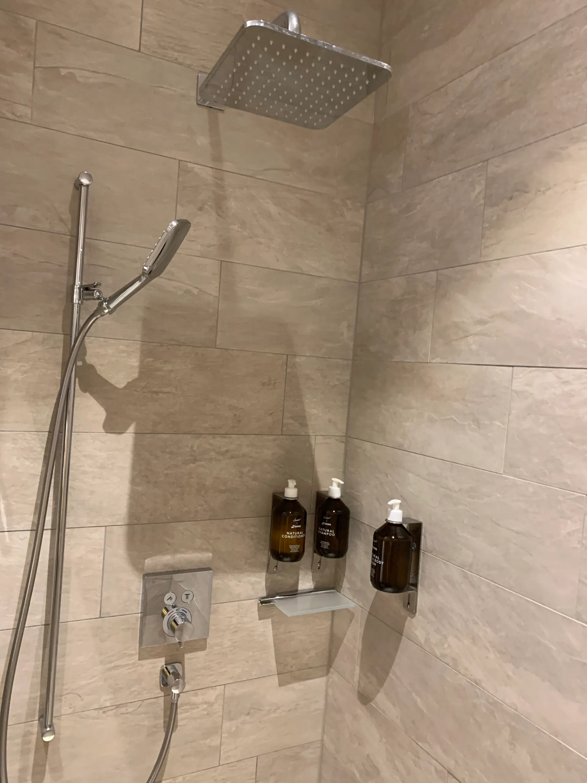 Duschbereich mit Regendusche und Flüssigseifenhalterungen