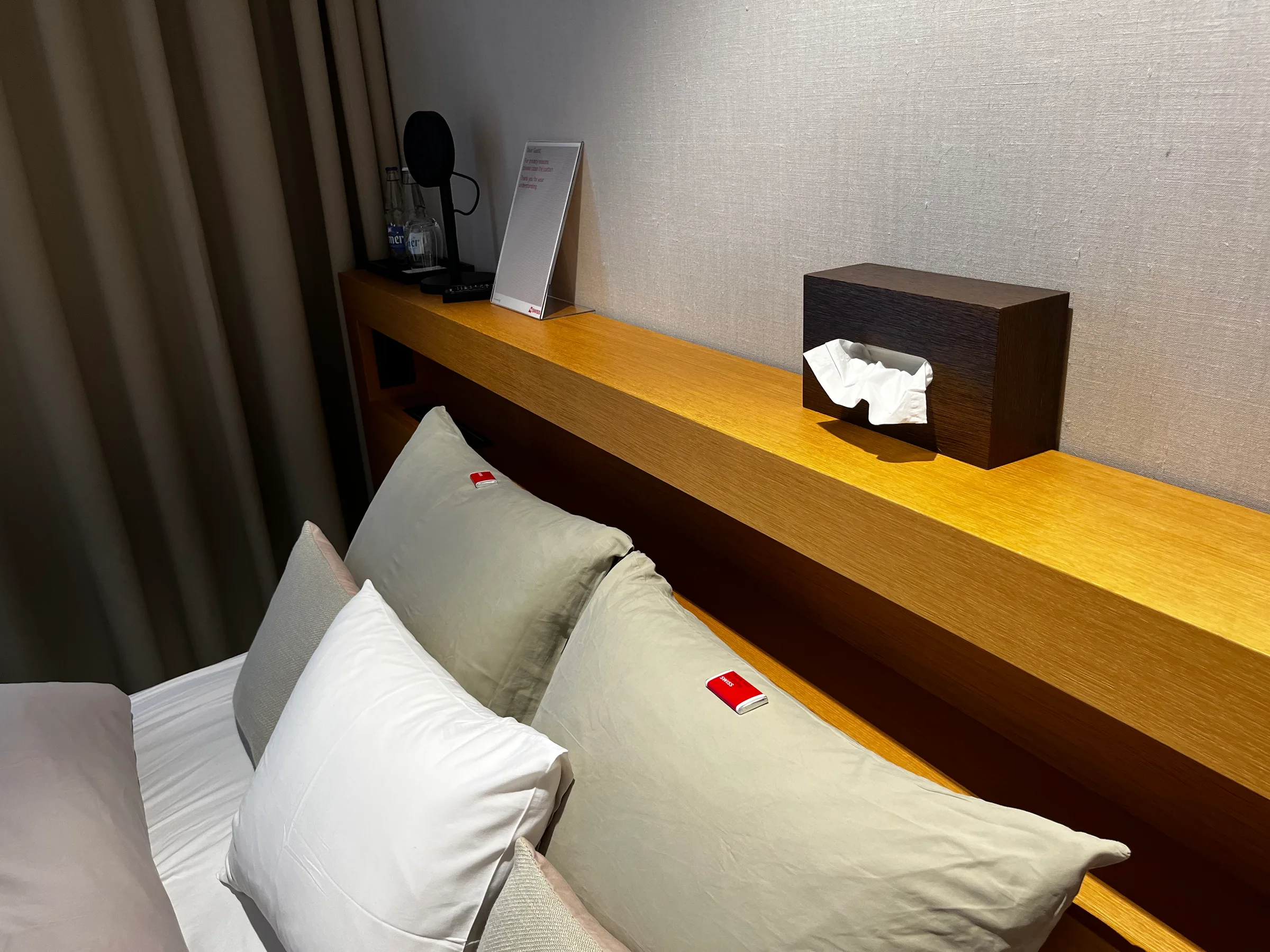 Hotelzimmer mit Doppelbett und Holzregal