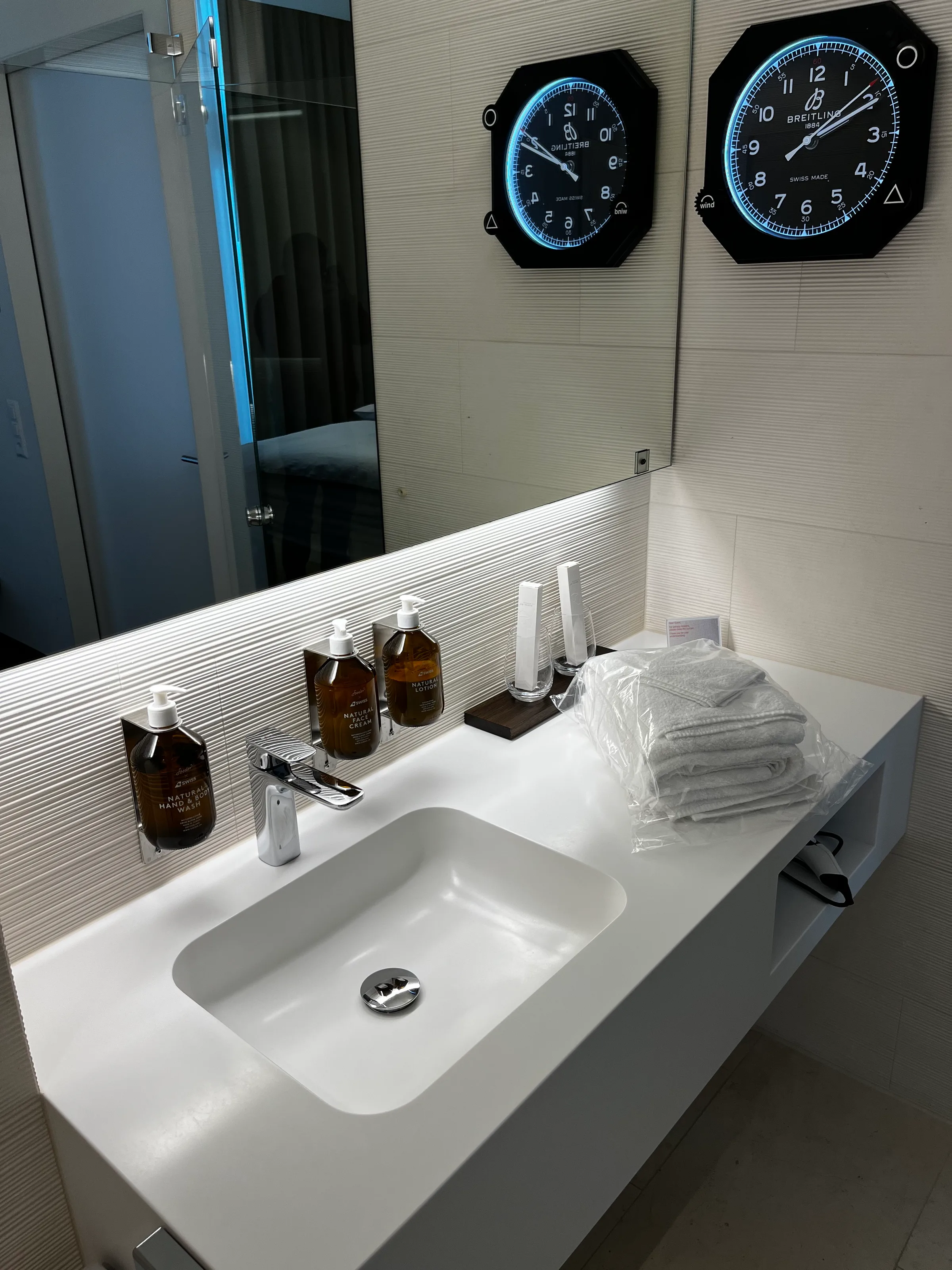 Waschbecken mit Spiegeln und Uhren im Flughafenlounge