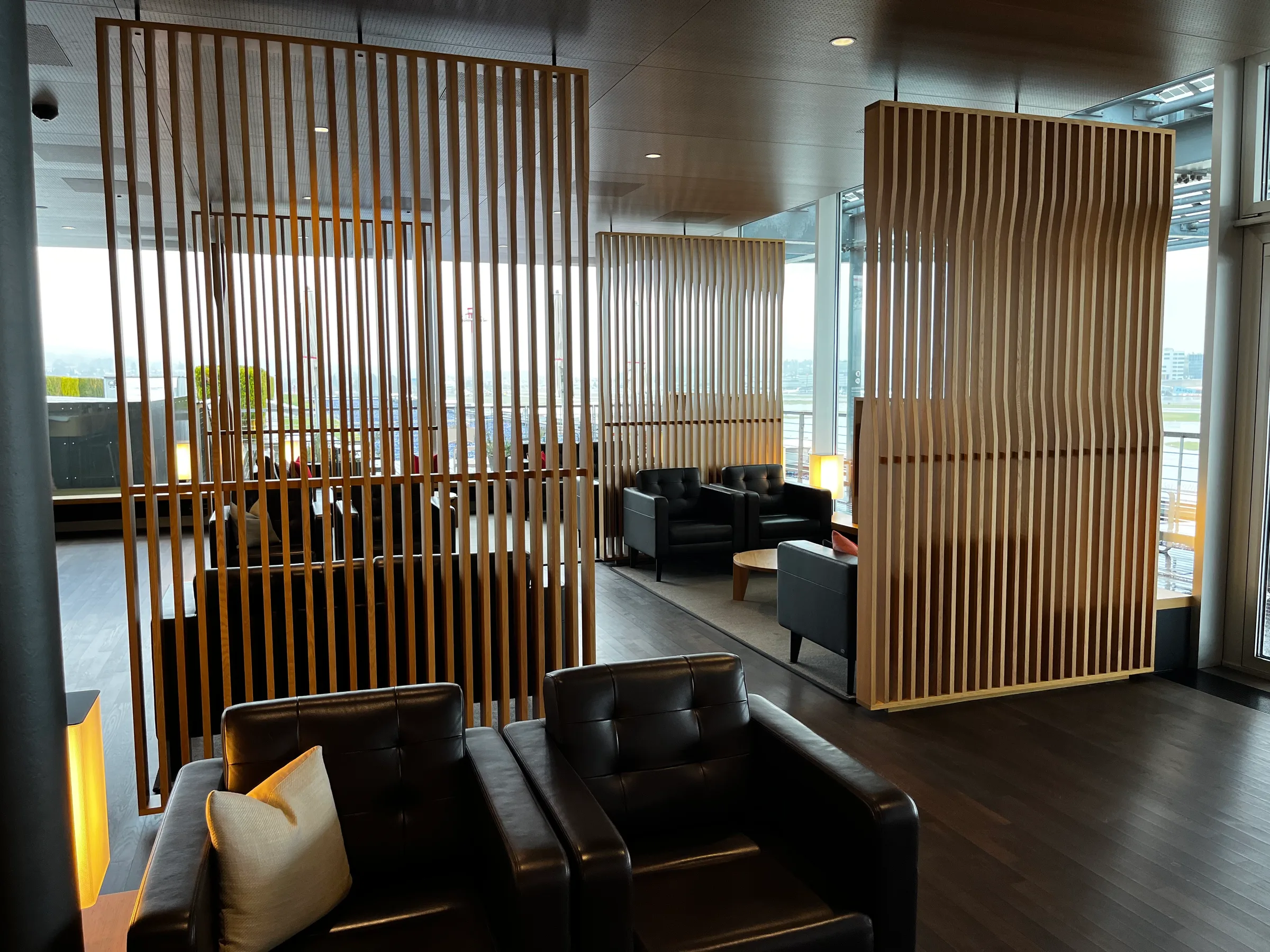 Lounge mit Holzschirmen und Ledersesseln
