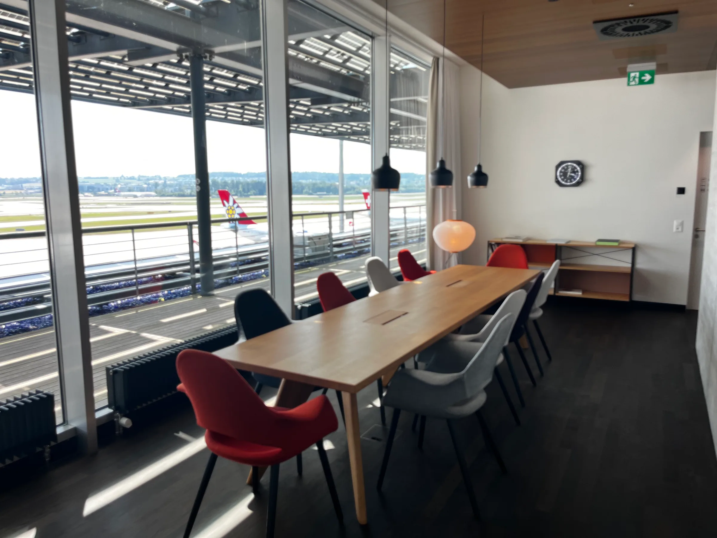 Lounge mit Tisch und Stühlen mit Blick auf Flughafen