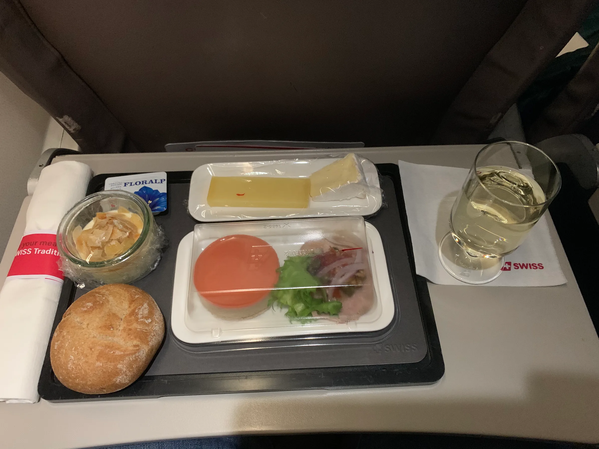 Flugzeugmenü mit Käse, Salat und Brot auf Tisch