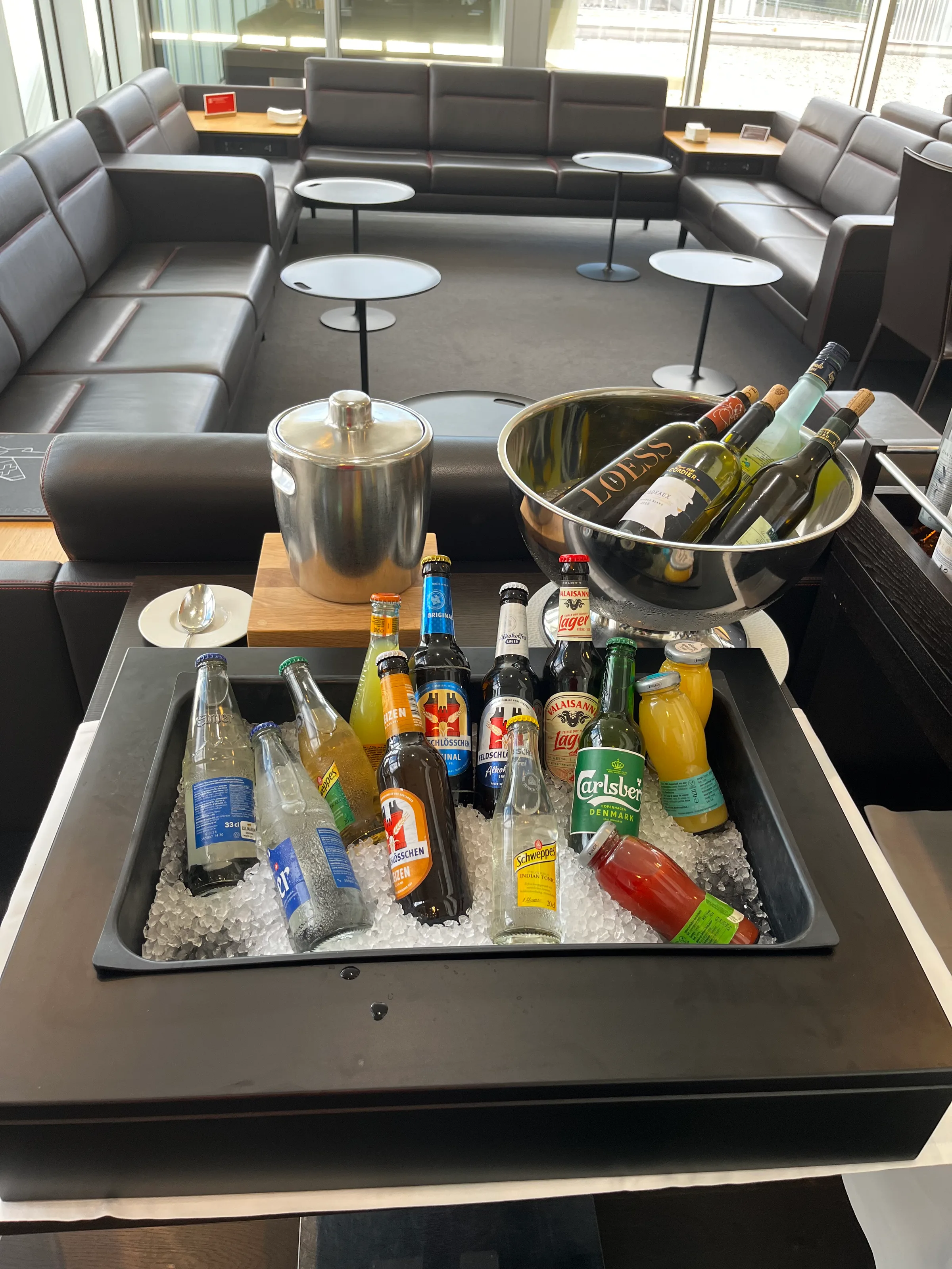 Getränkebuffet mit Eiswürfeln und verschiedenen Getränken auf Tisch im Loungebereich