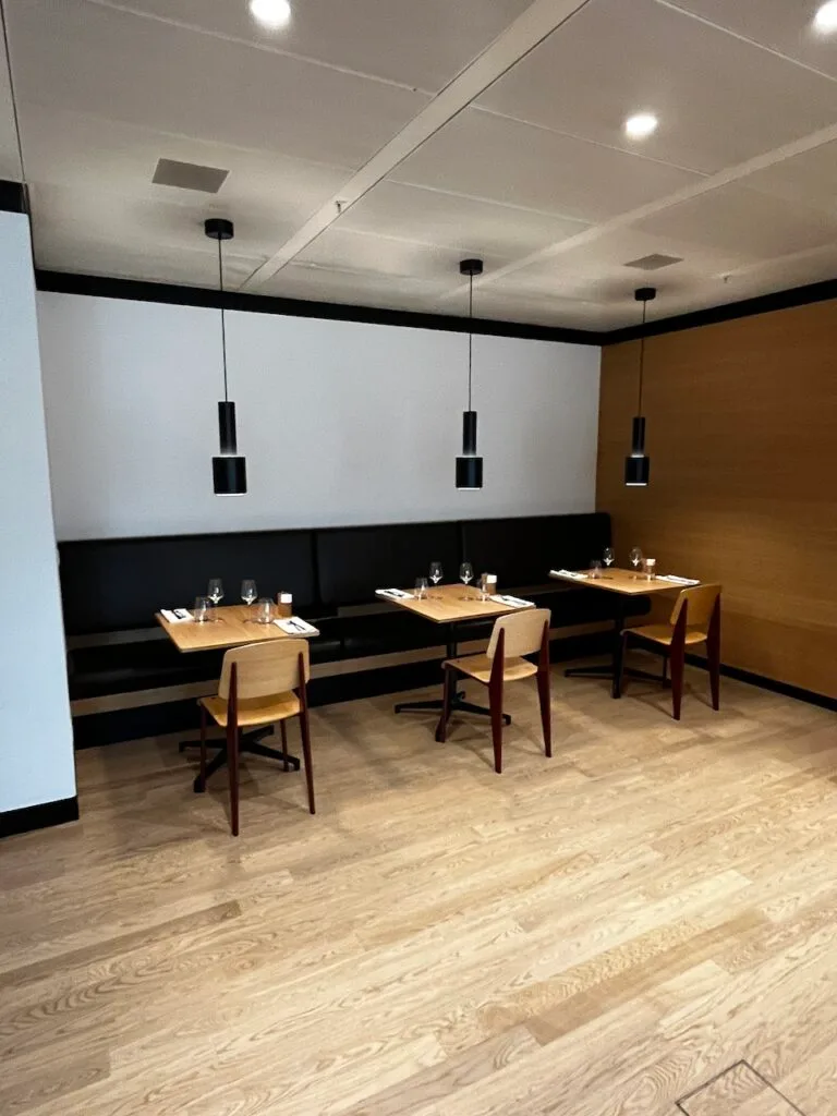 Ruhiger Loungebereich mit Holzboden und schlichten Tischen