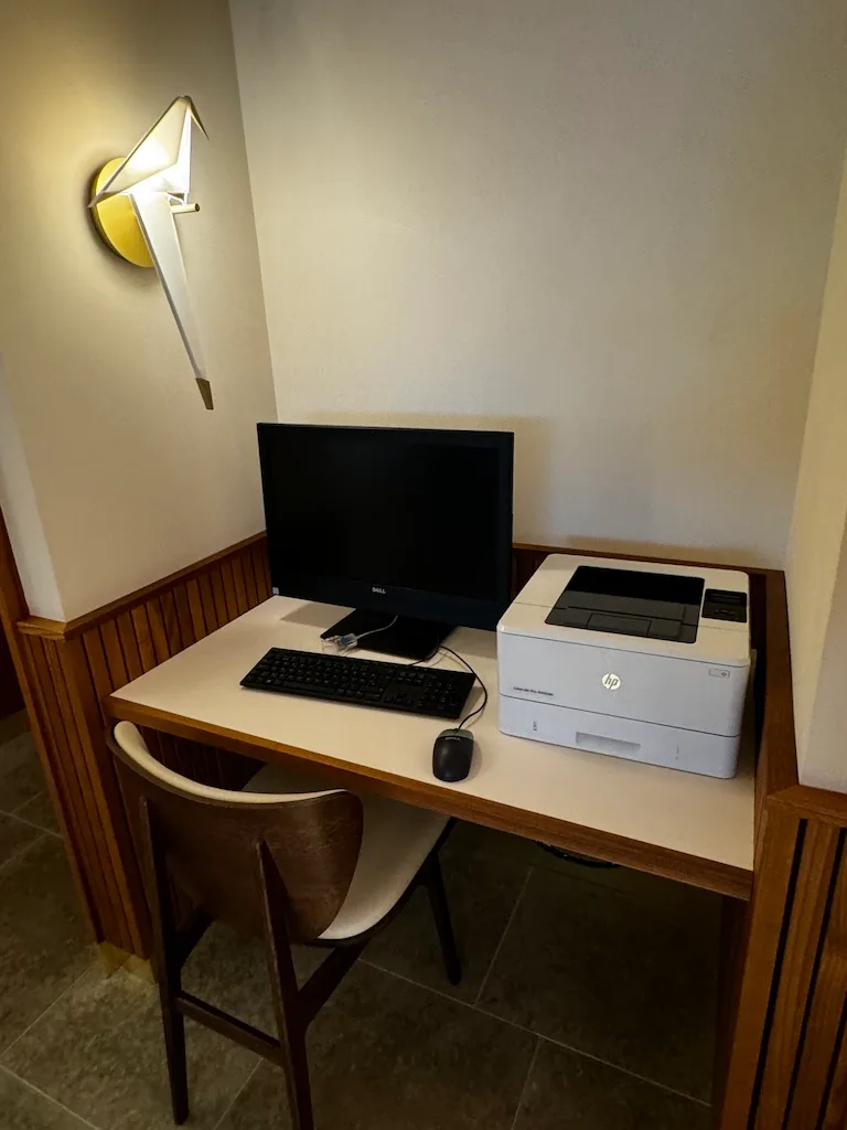 Arbeitsplatz mit Monitor, Tastatur und Drucker in einem Flughafensalon
