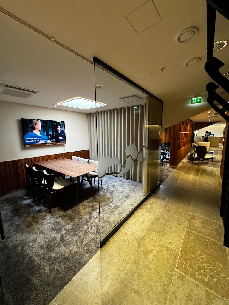 Gemeinschaftsraum mit Tisch und Fernseher im Flughafenlounge