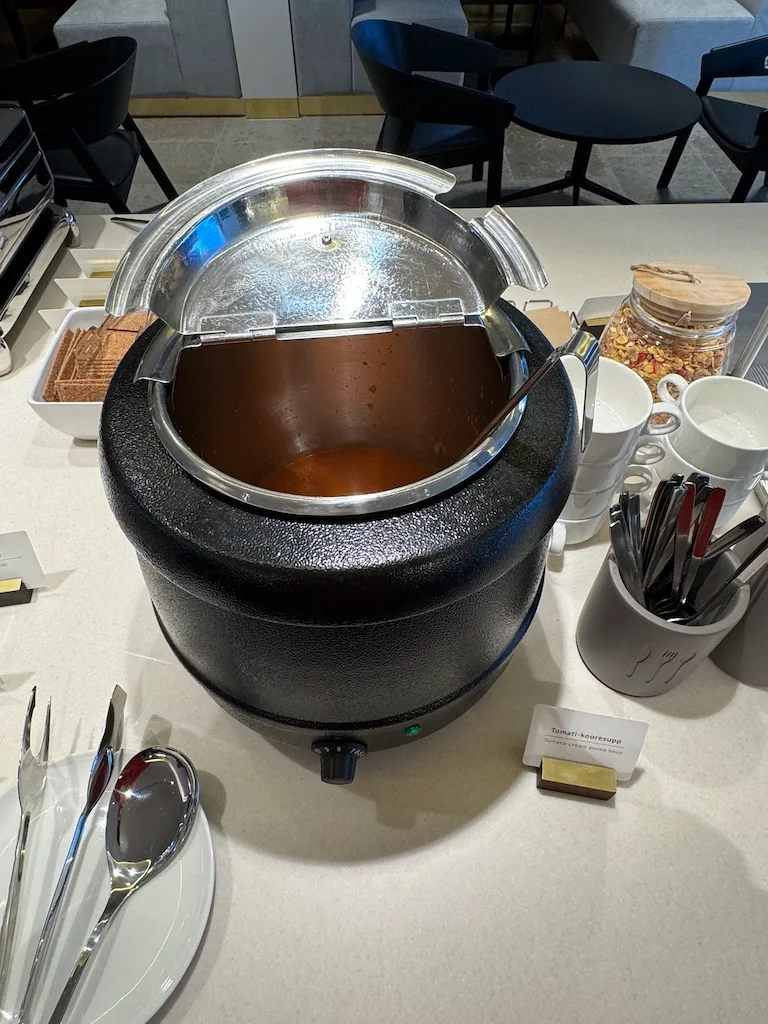 Warmes Suppentopf auf dem Frühstückstisch im Flughafenlounge