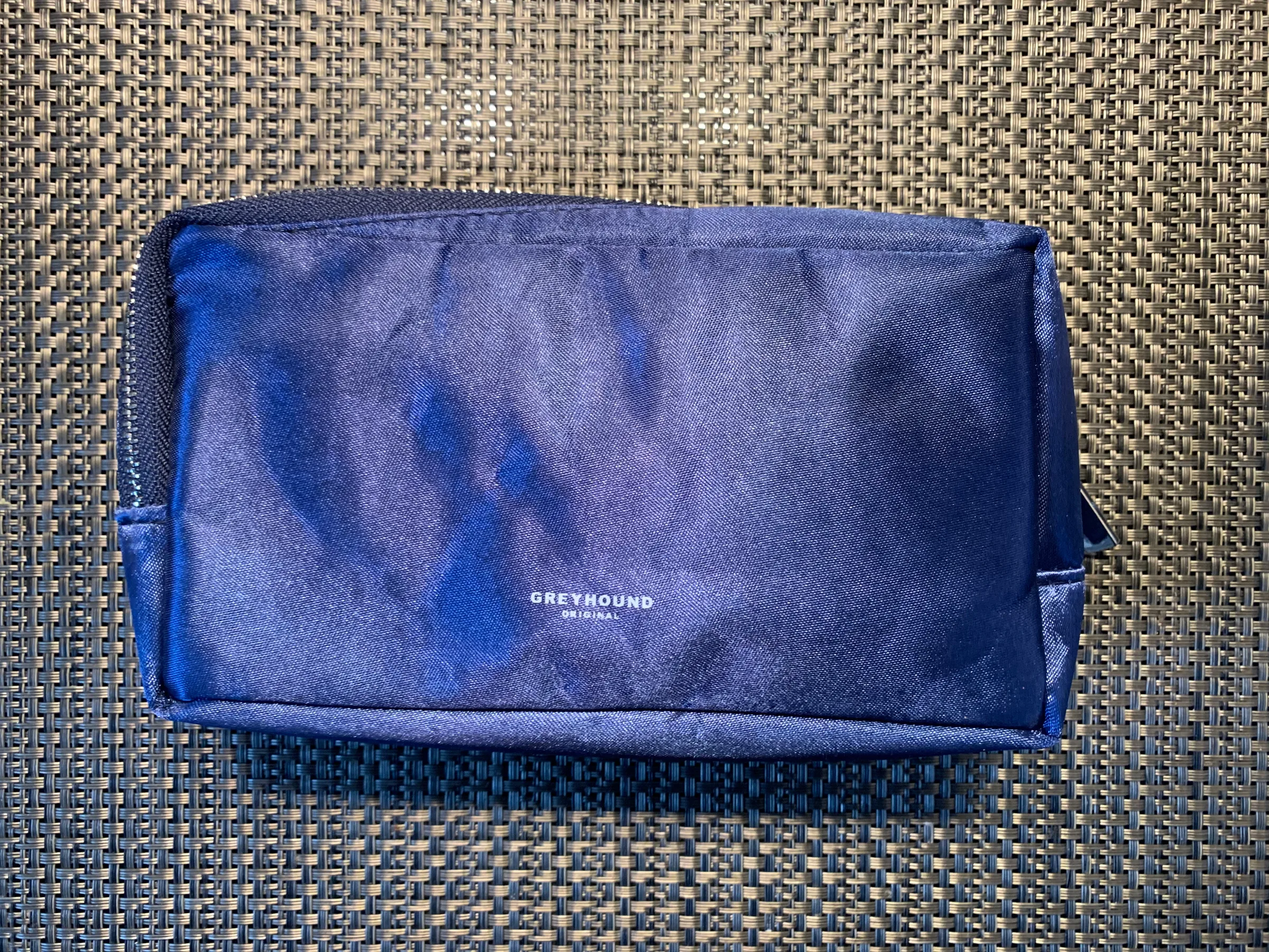 Blauer Kosmetiktasche mit Aufdruck 'GREYHOUND' auf Textiloberfläche