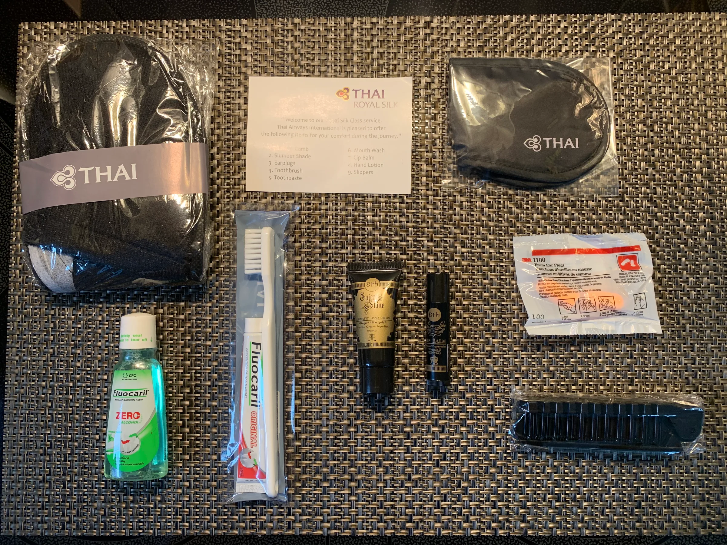 Graue Thai Airways Royal Silk Amenity Kit mit verschiedenen Gegenständen
