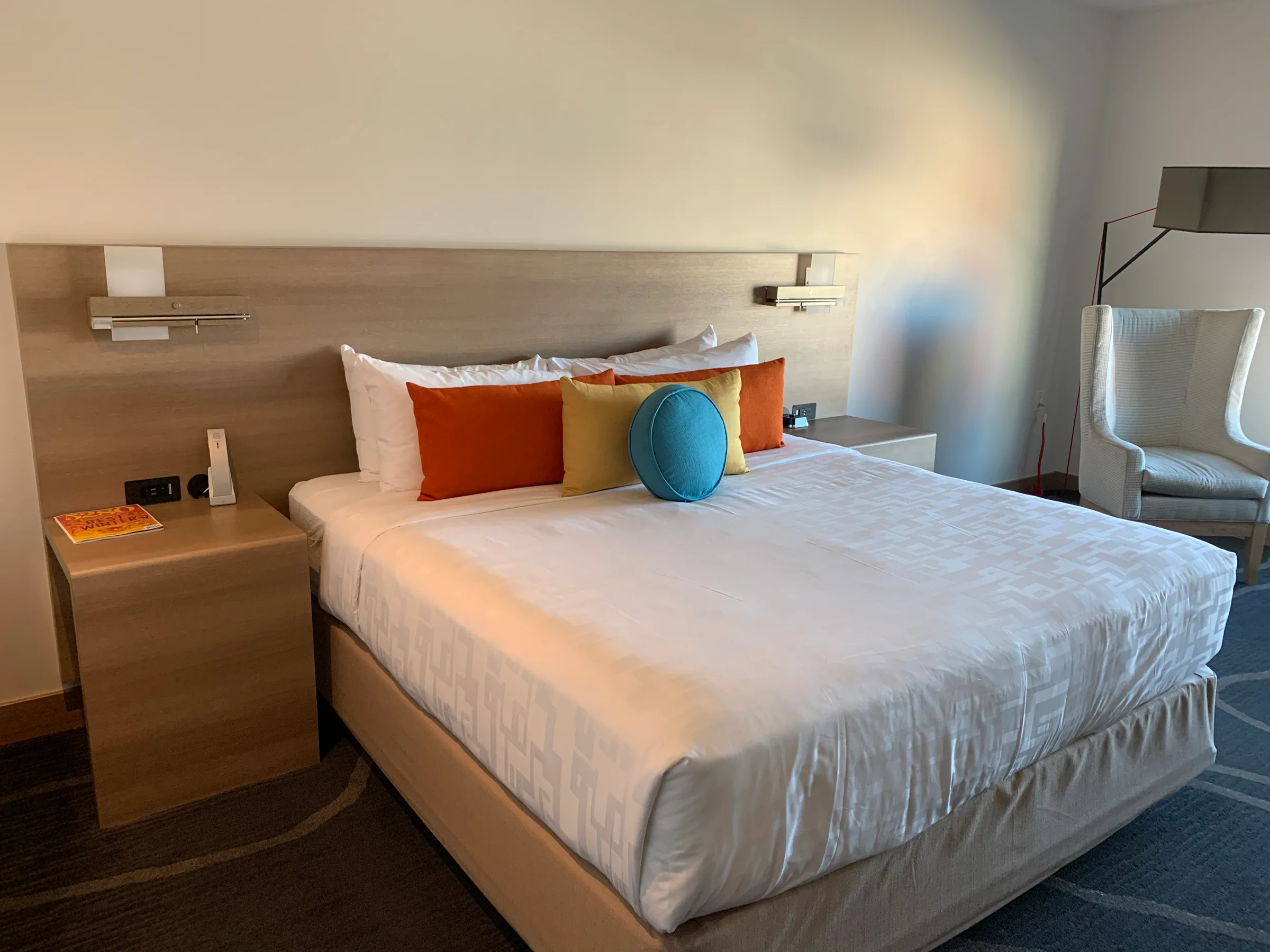 Doppelbett im Hotelzimmer mit bunten Kissen