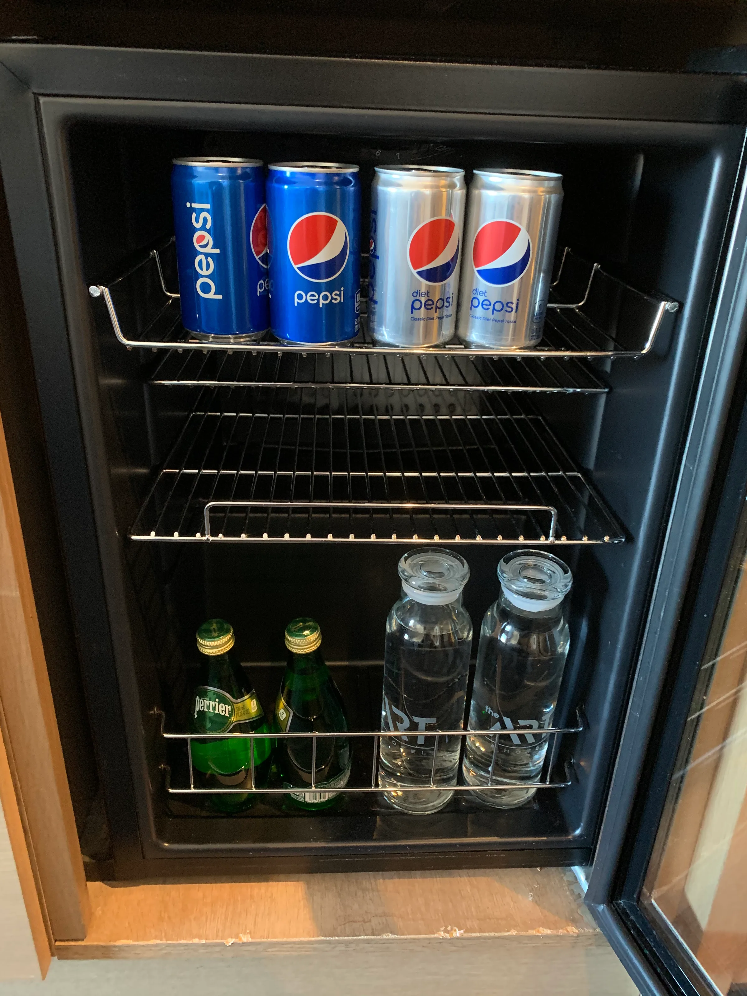 Hotelkühlschrank mit Pepsi-Dosen und Perrier-Flaschen
