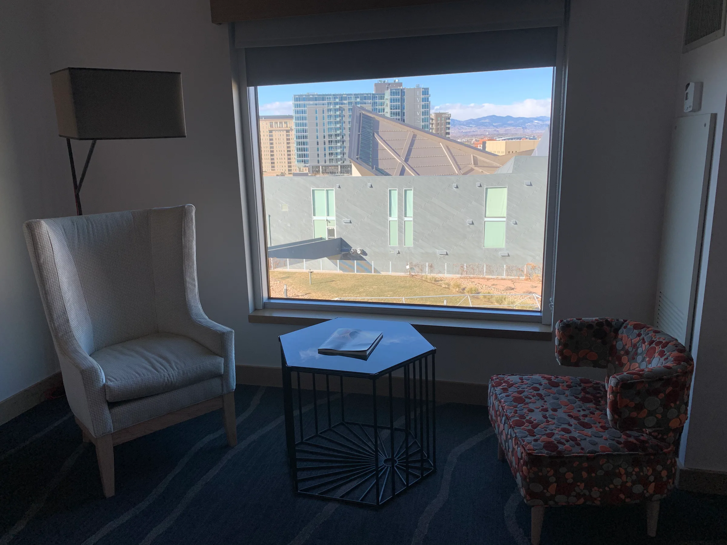 Hotelzimmer mit Sessel und Couch vor großem Fenster