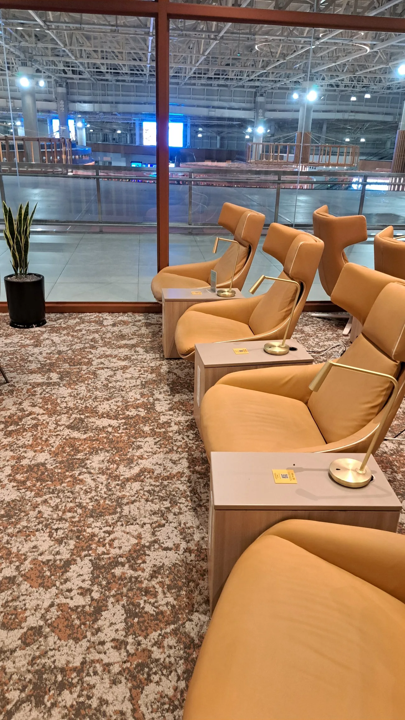 Lounge mit gelben Sesseln und Couchen vor Glaswand