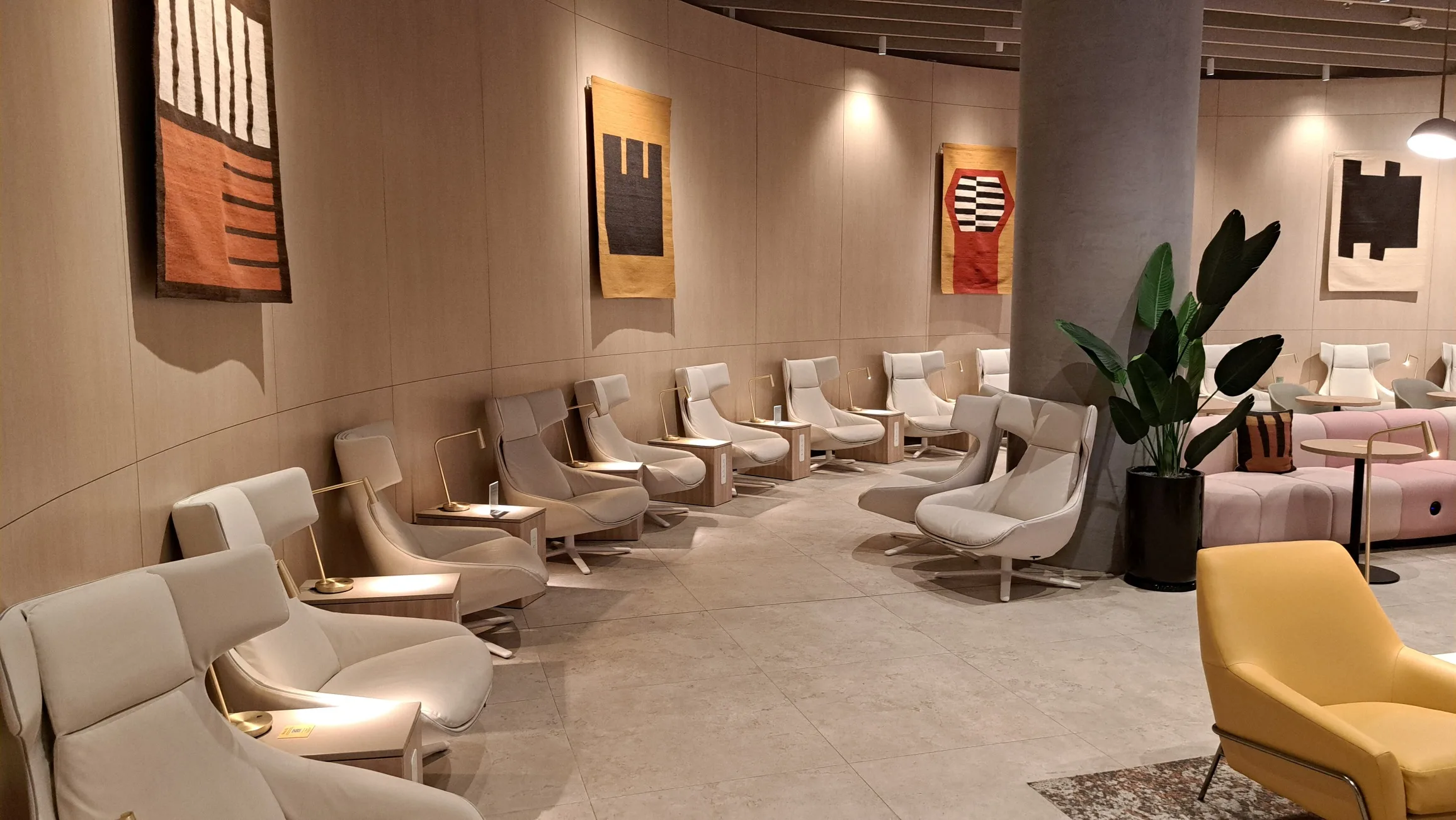 Lounge mit weißen Sesseln und Wandteppichen
