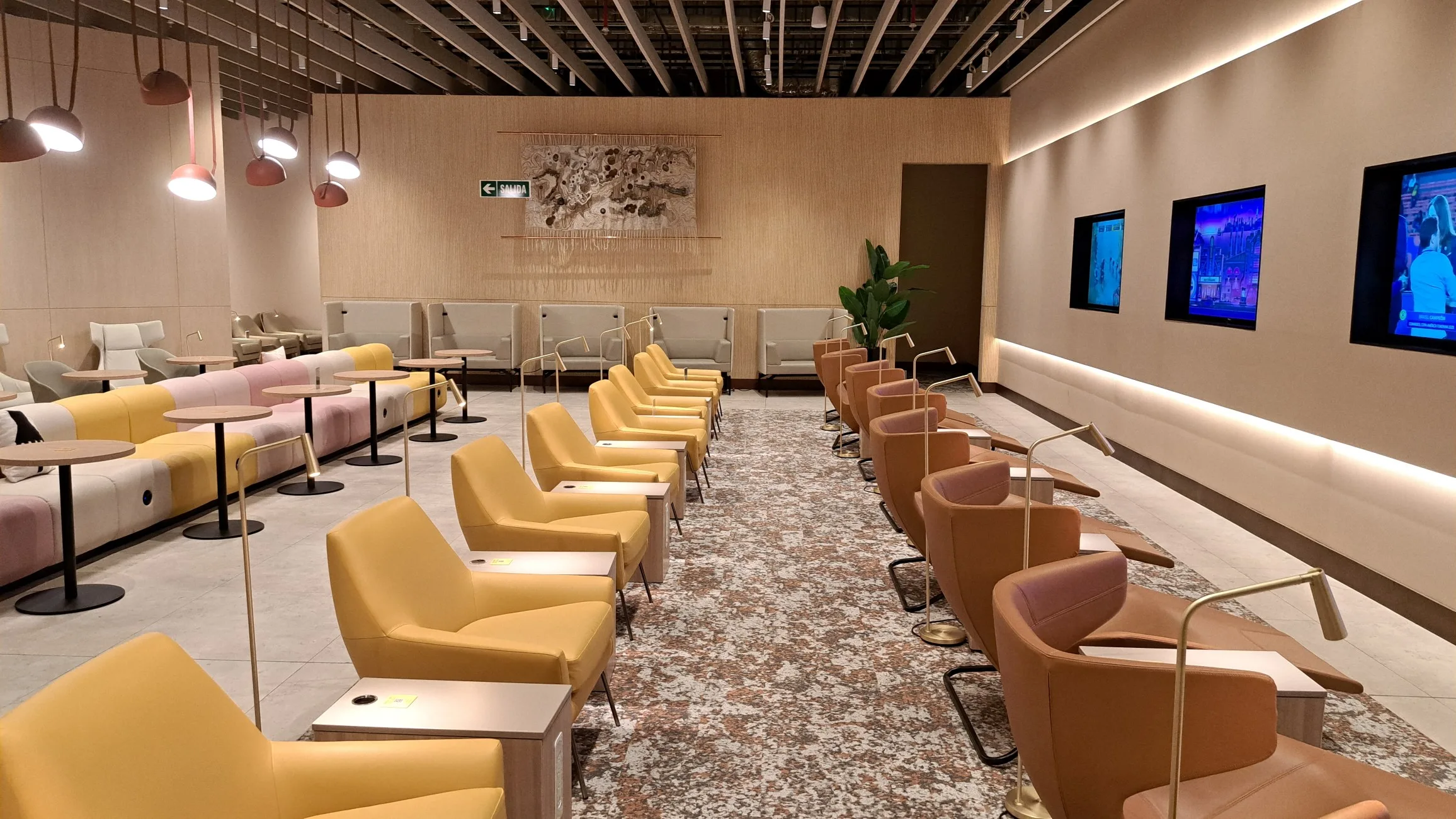 Lounge mit orangefarbenen Sesseln und rosa Sofas
