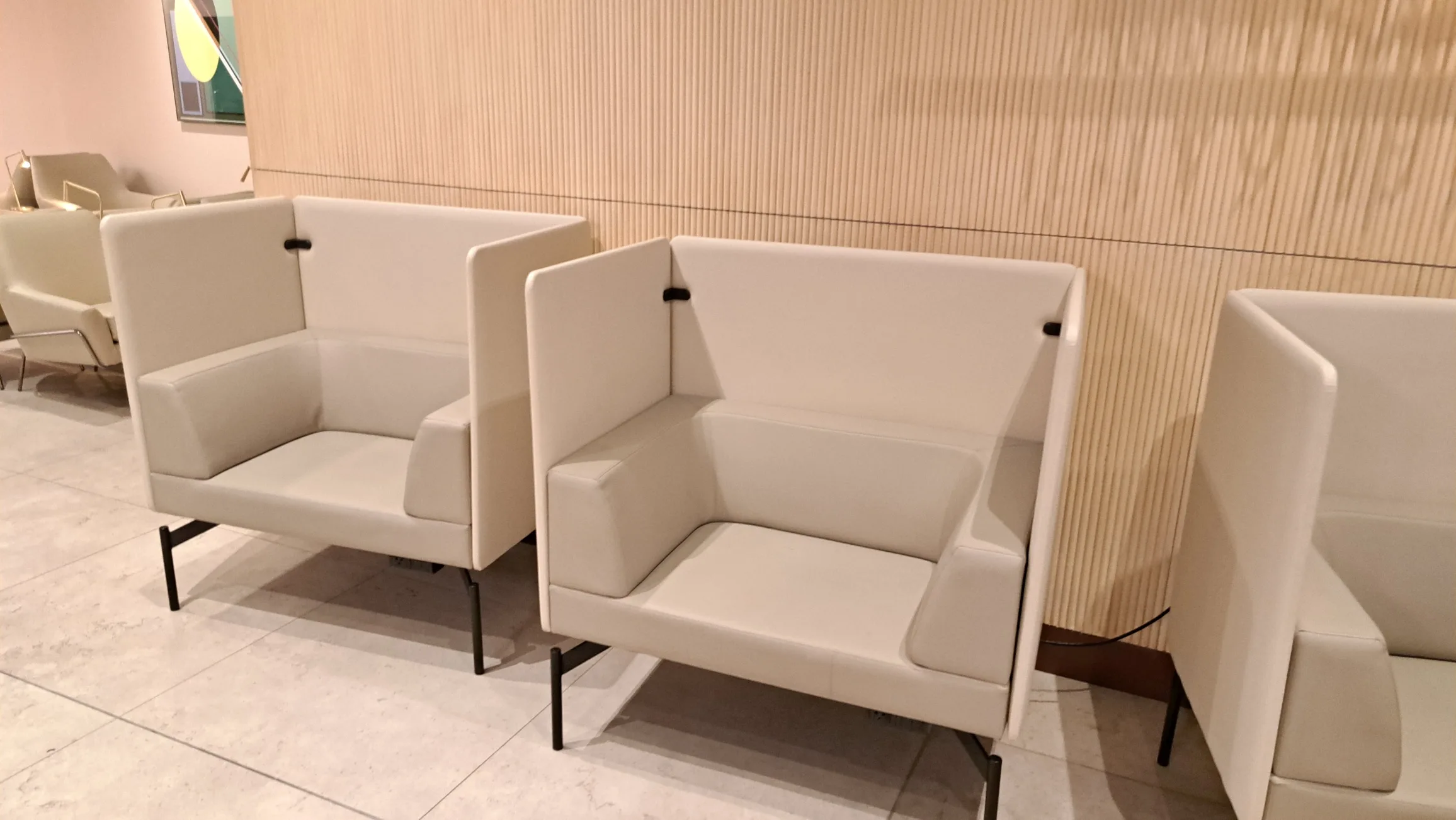 Weißer Sessel mit geteiltem Rückenlehnen in Loungesituation